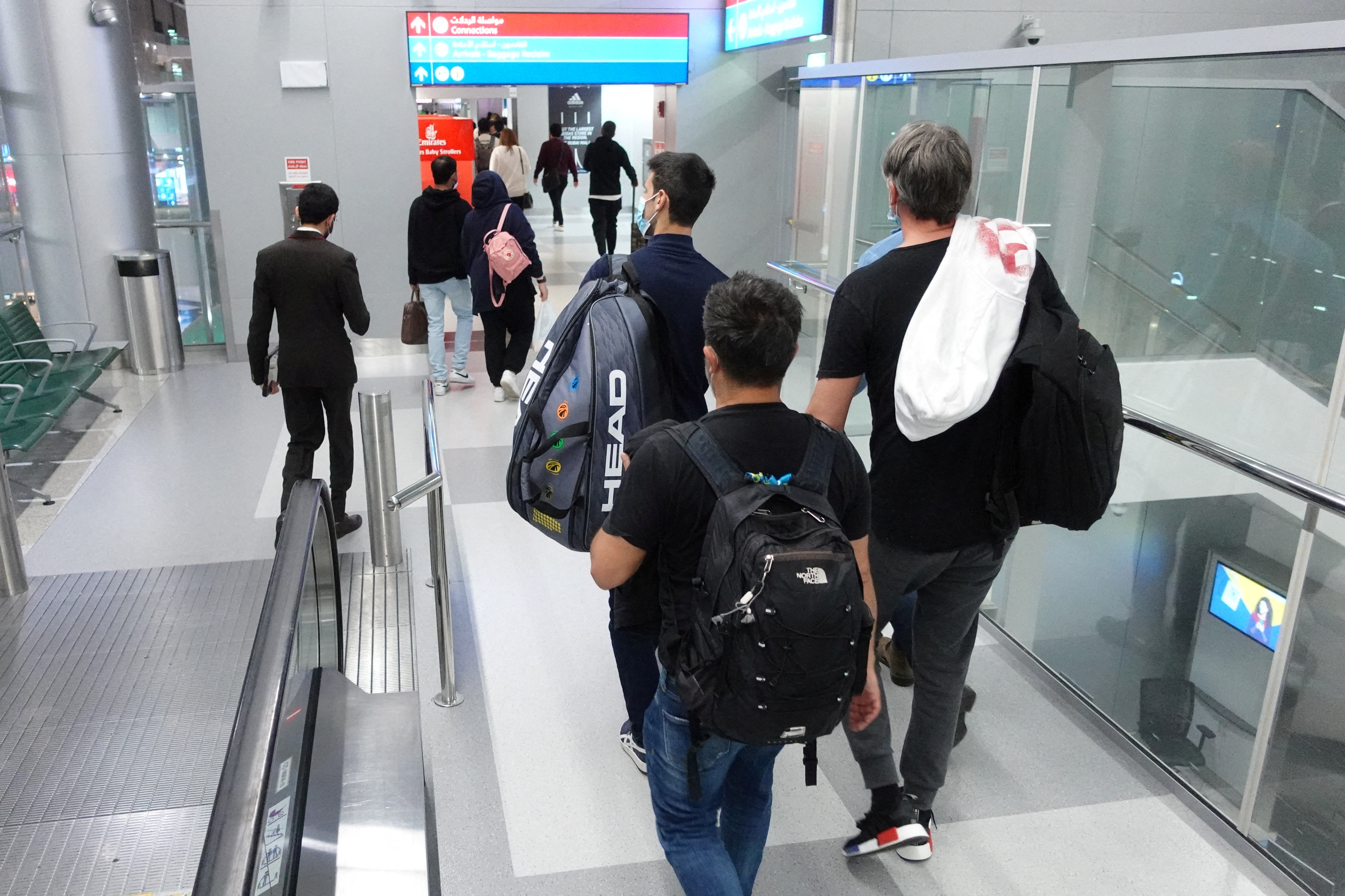 Serbian tennis player Novak Djokovic walks with his team after landing at Dubai Airport after the Australian Federal Court upheld a government decision to cancel his visa to play in the Australian Open, in Dubai, United Arab Emirates, January 17, 2022. REUTERS/Loren Elliott