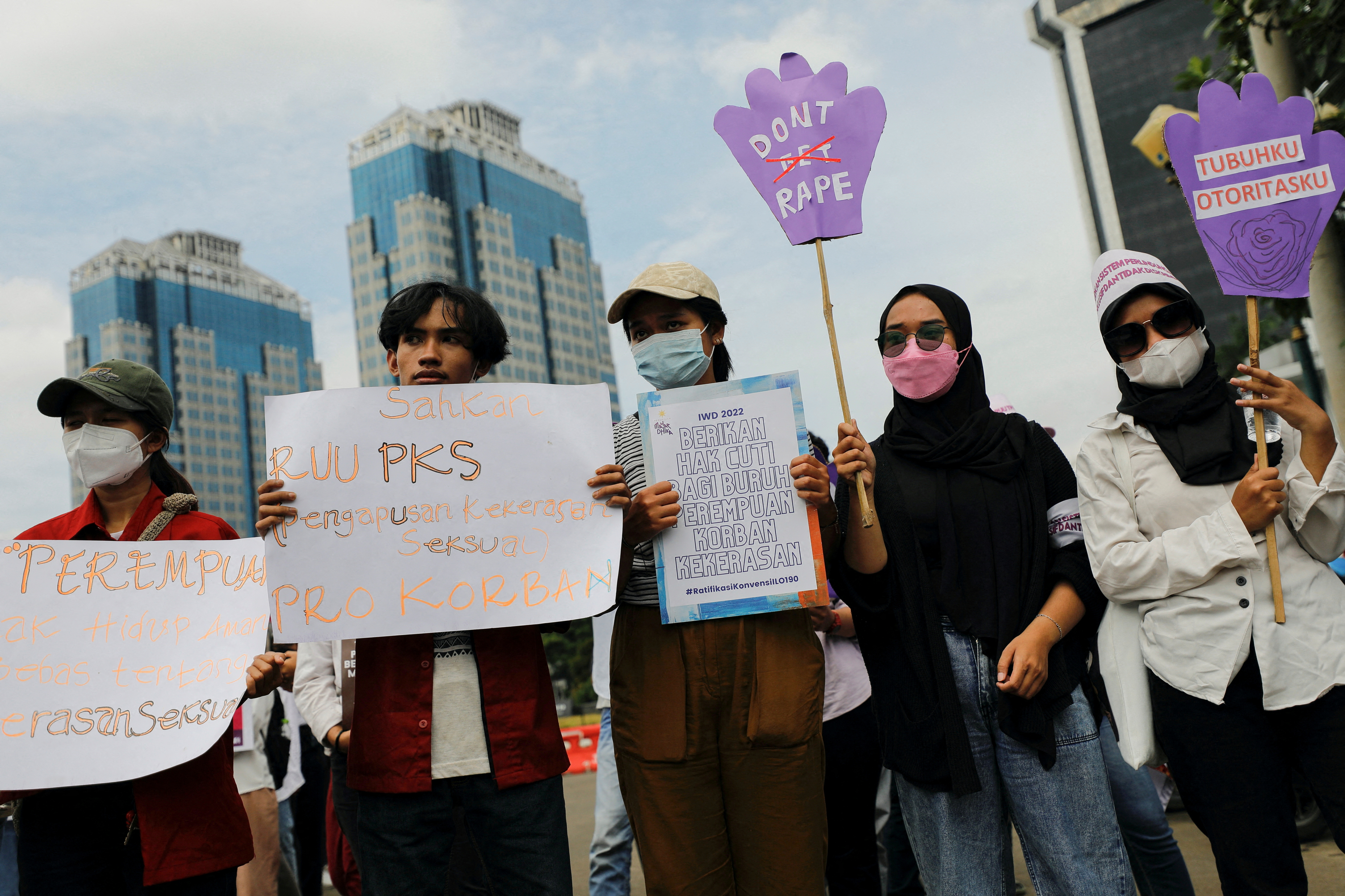 Activists carrying placards take part in a rally to support women's rights calling for gender equality and to protest against gender discrimination, during the International Women's Day outside the National Monument (Monas) complex in Jakarta