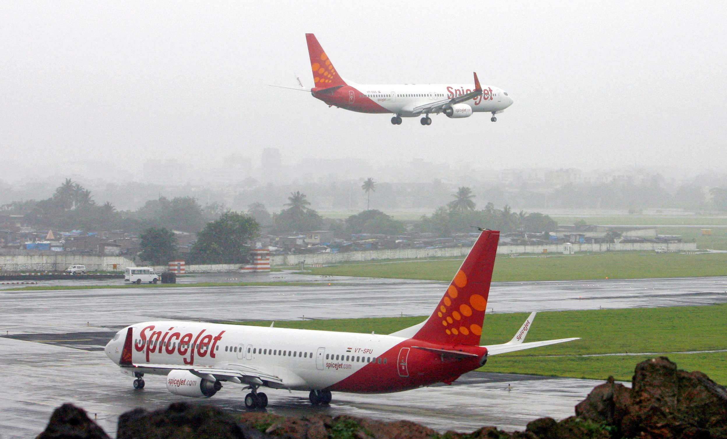 India's SpiceJet aircrafts prepare for landing and take-off at the airport in Mumbai