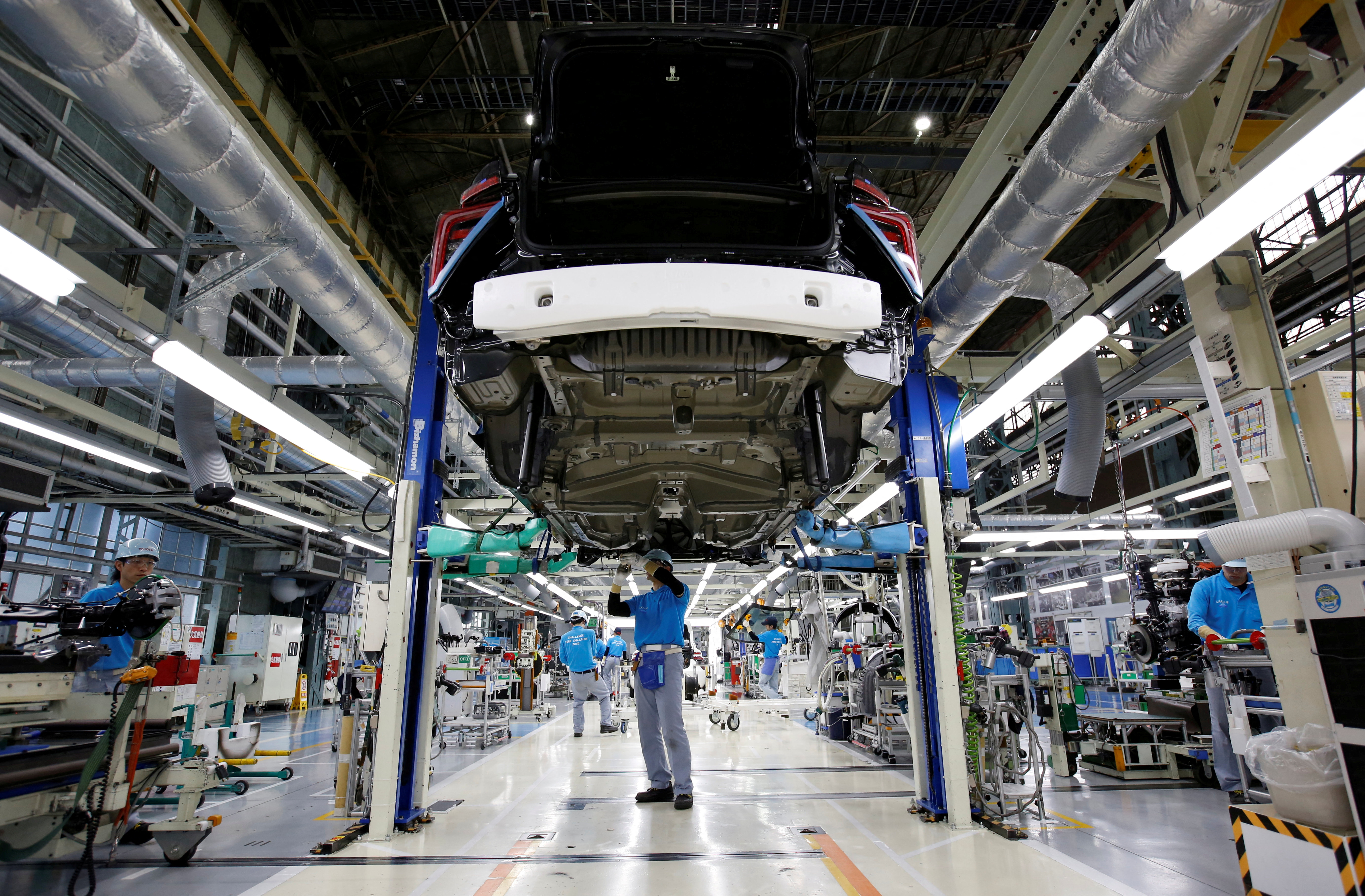 Employees of Toyota Motor Corp. work on assembly line