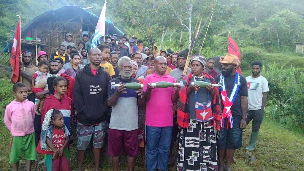 Papuans hold unexploded mortars following aerial attacks by Indonesian forces in Kiwirok, Pegunungan Bintang regency
