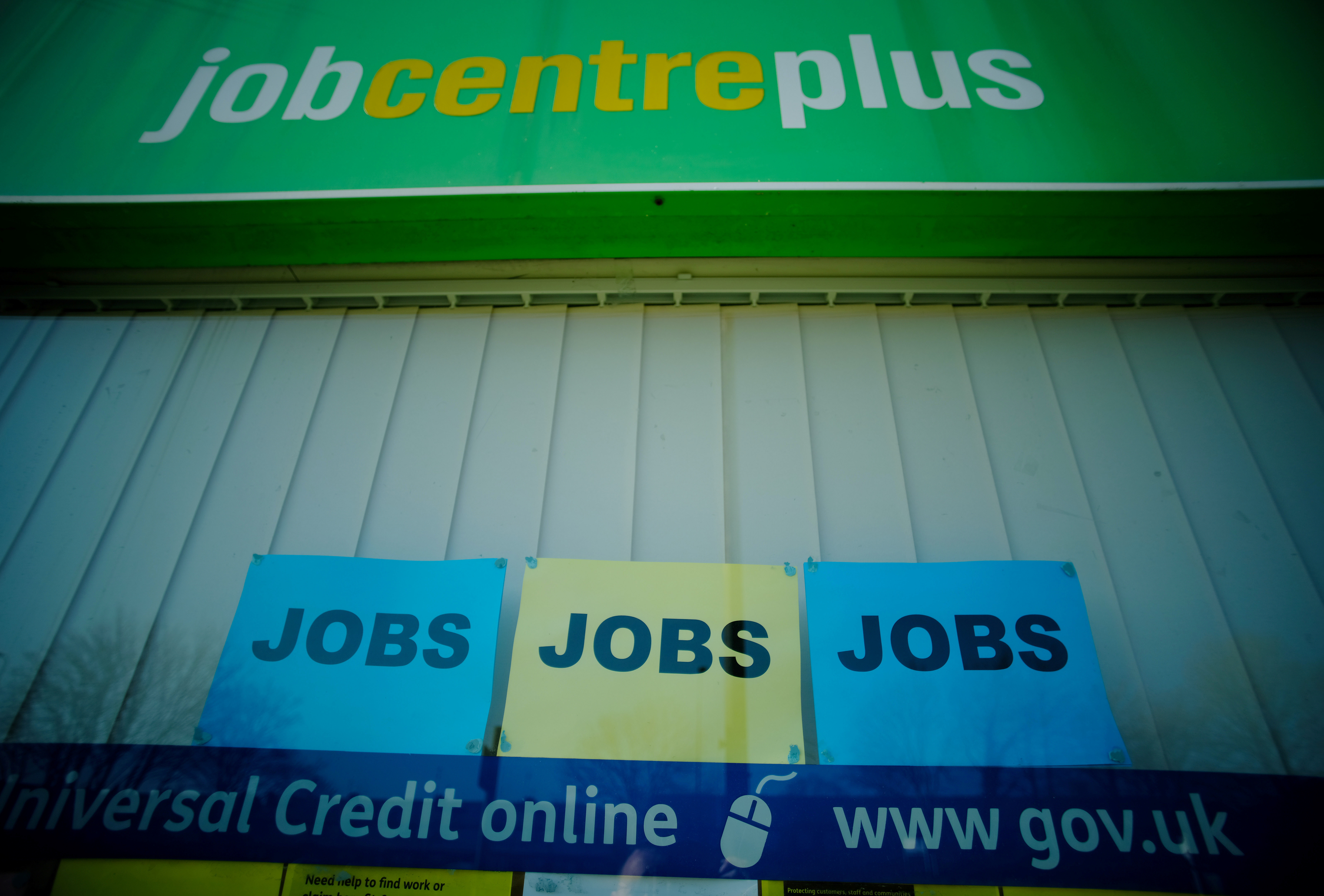 Adverts for jobs are seen in the window of a Jobcentre Plus  in Manchester