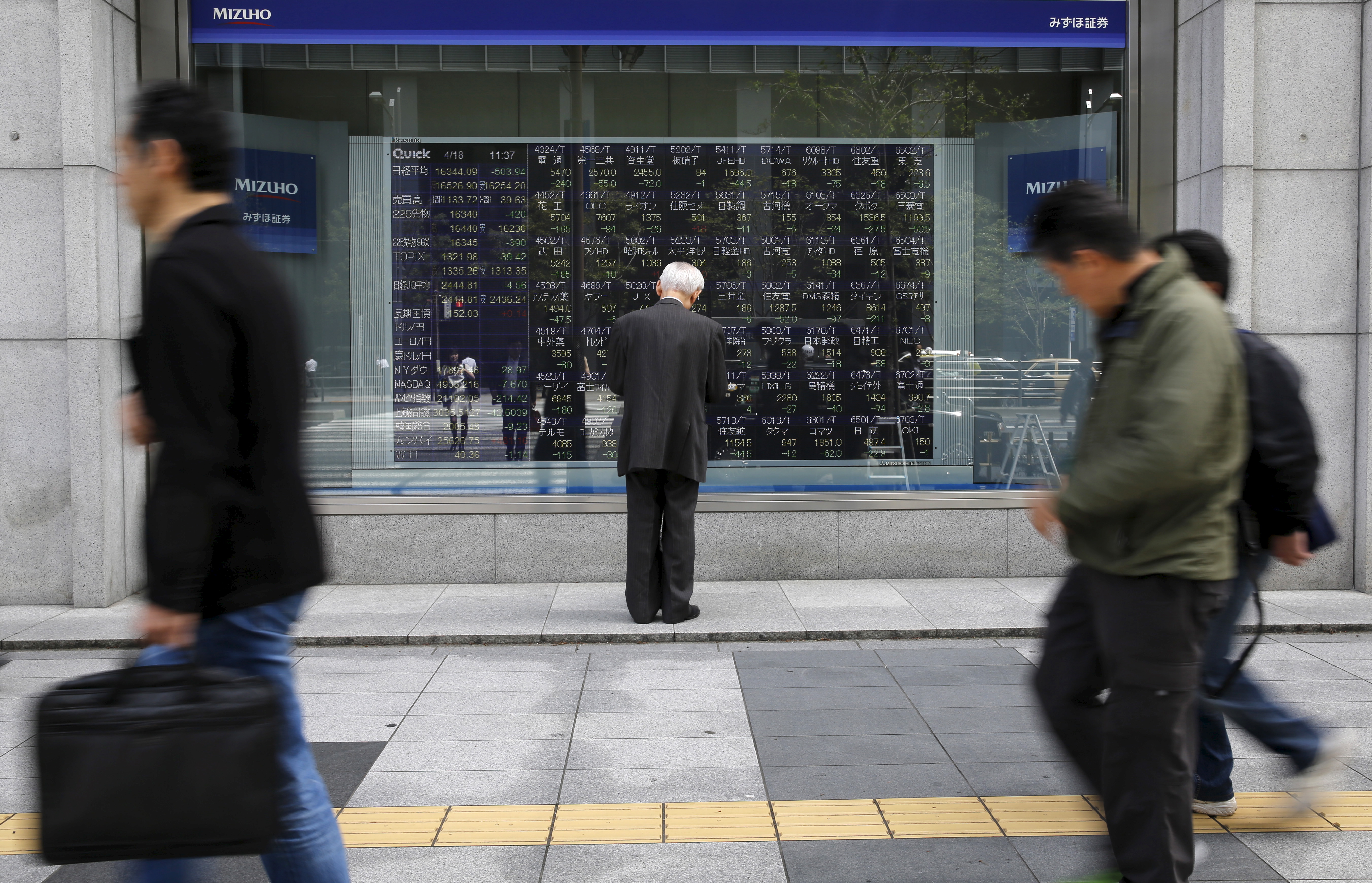 A man looks at a stock quotation board outside a brokerage in Tokyo, Japan, April 18, 2016. REUTERS/Toru Hanai   