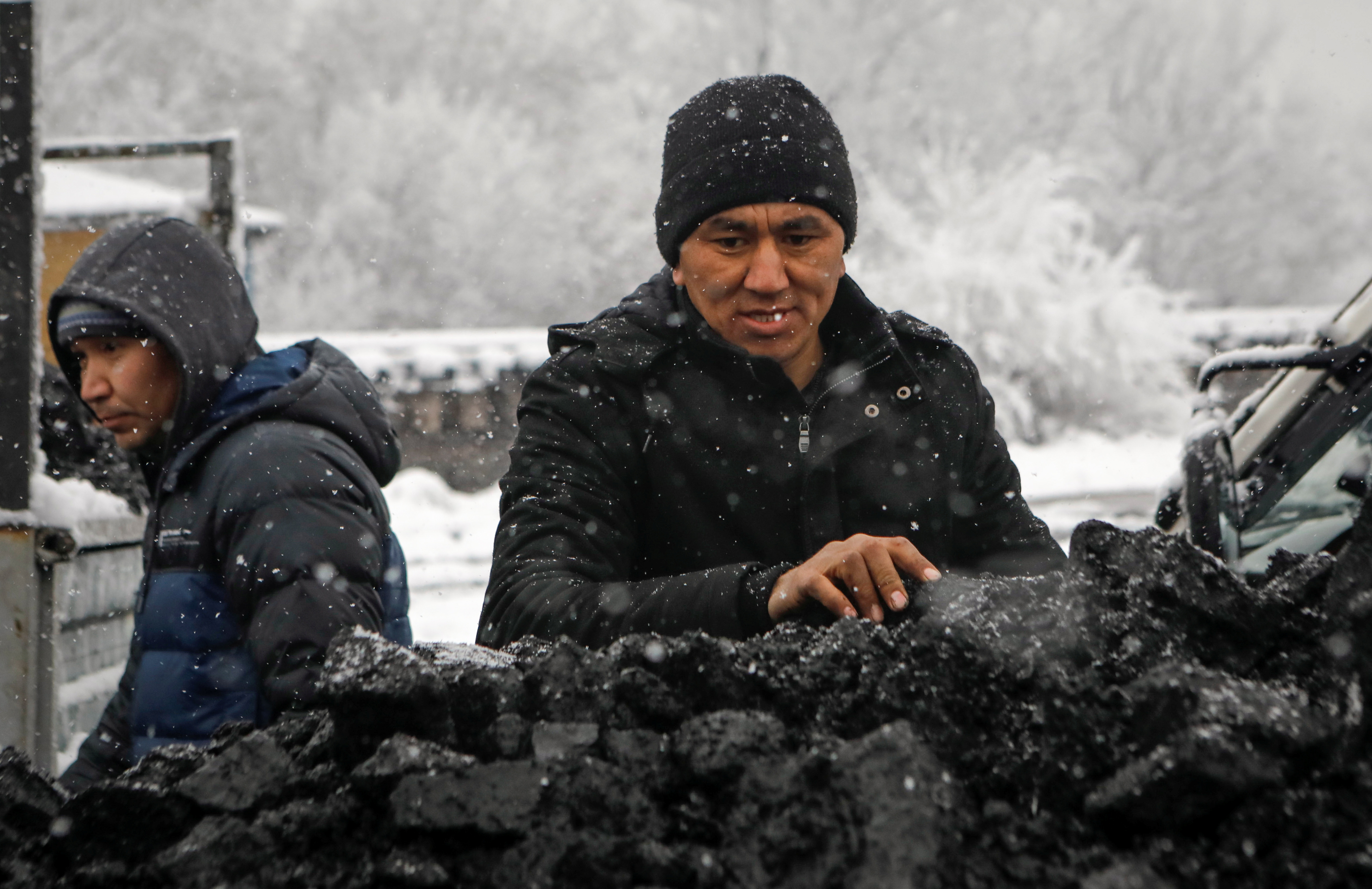 A man stands next to a lorry loaded with coal amid the energy crunch in Bishkek
