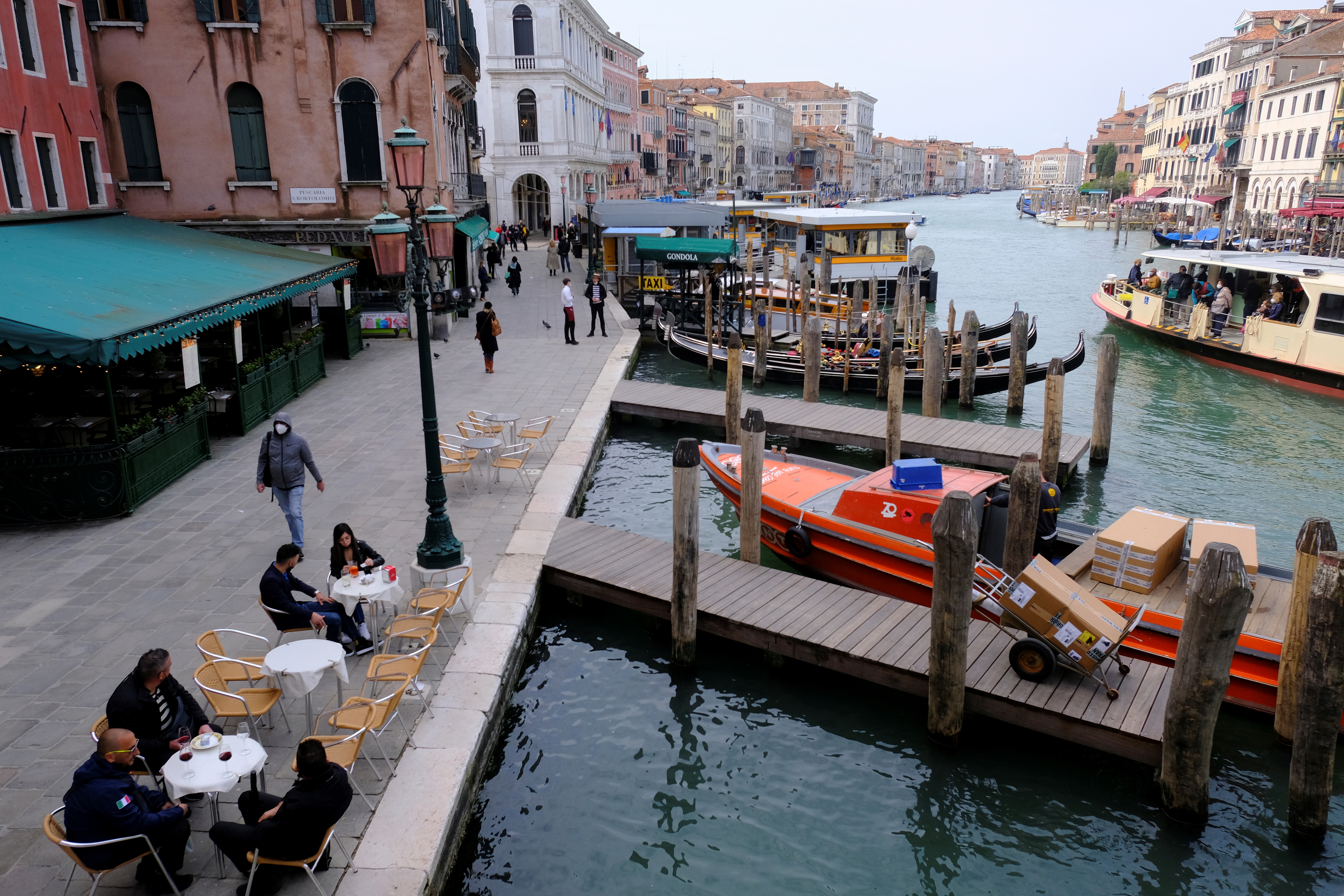Italians sit at a bar as much of the country becomes a 'yellow zone', easing coronavirus disease (COVID-19) restrictions allowing bars and restaurants to open for sit-down food and drinks at outdoor tables, in Venice, Italy, April 26, 2021. REUTERS/Manuel Silvestri