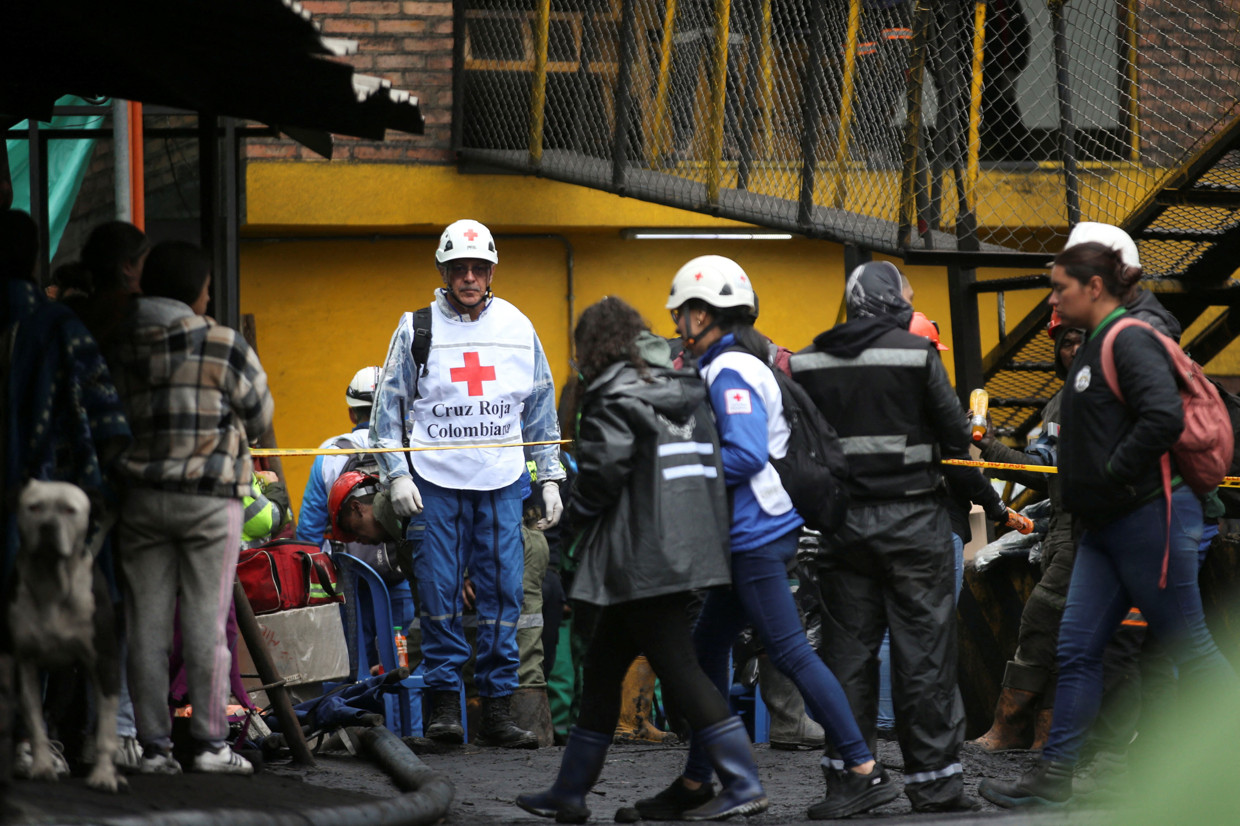 People wait during the search and rescue work of miners trapped following the explosion of a mine in Sutatausa