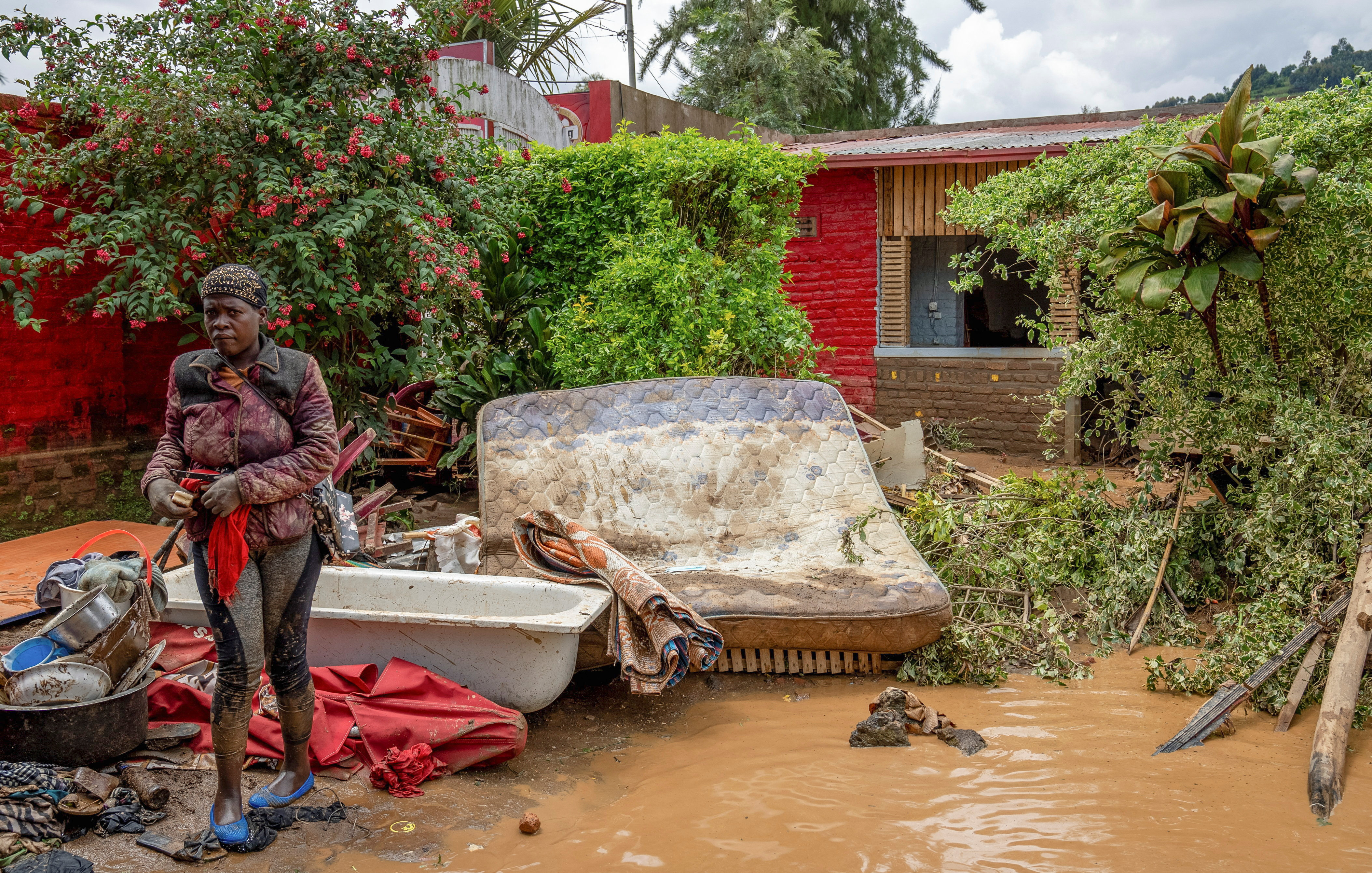 A resident salvages her household items washed away following rains that triggered flooding and landslides in Rubavu district