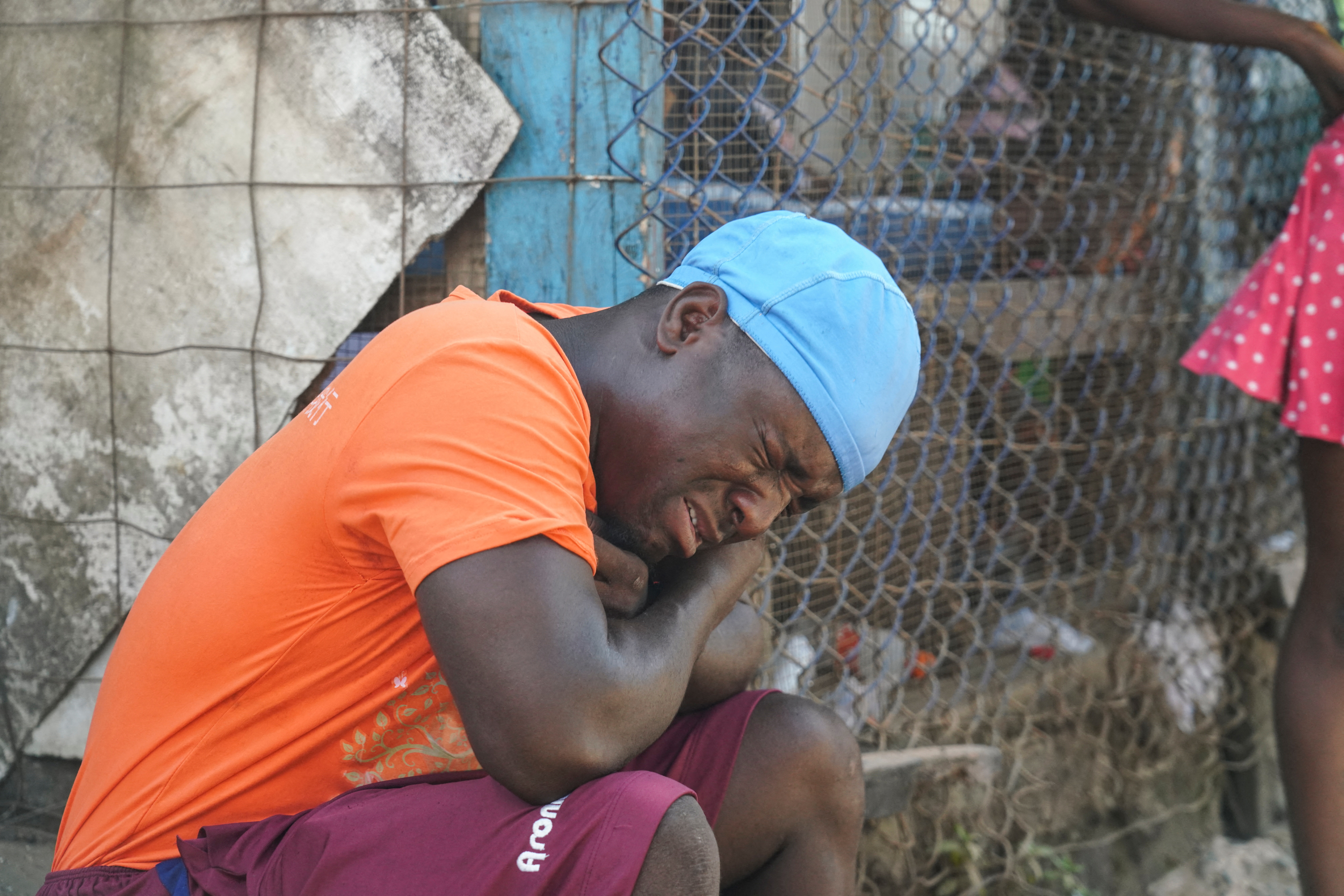 A man reacts as he sits outside the hospital after a stampede at a church gathering killed 29 people in Monrovia
