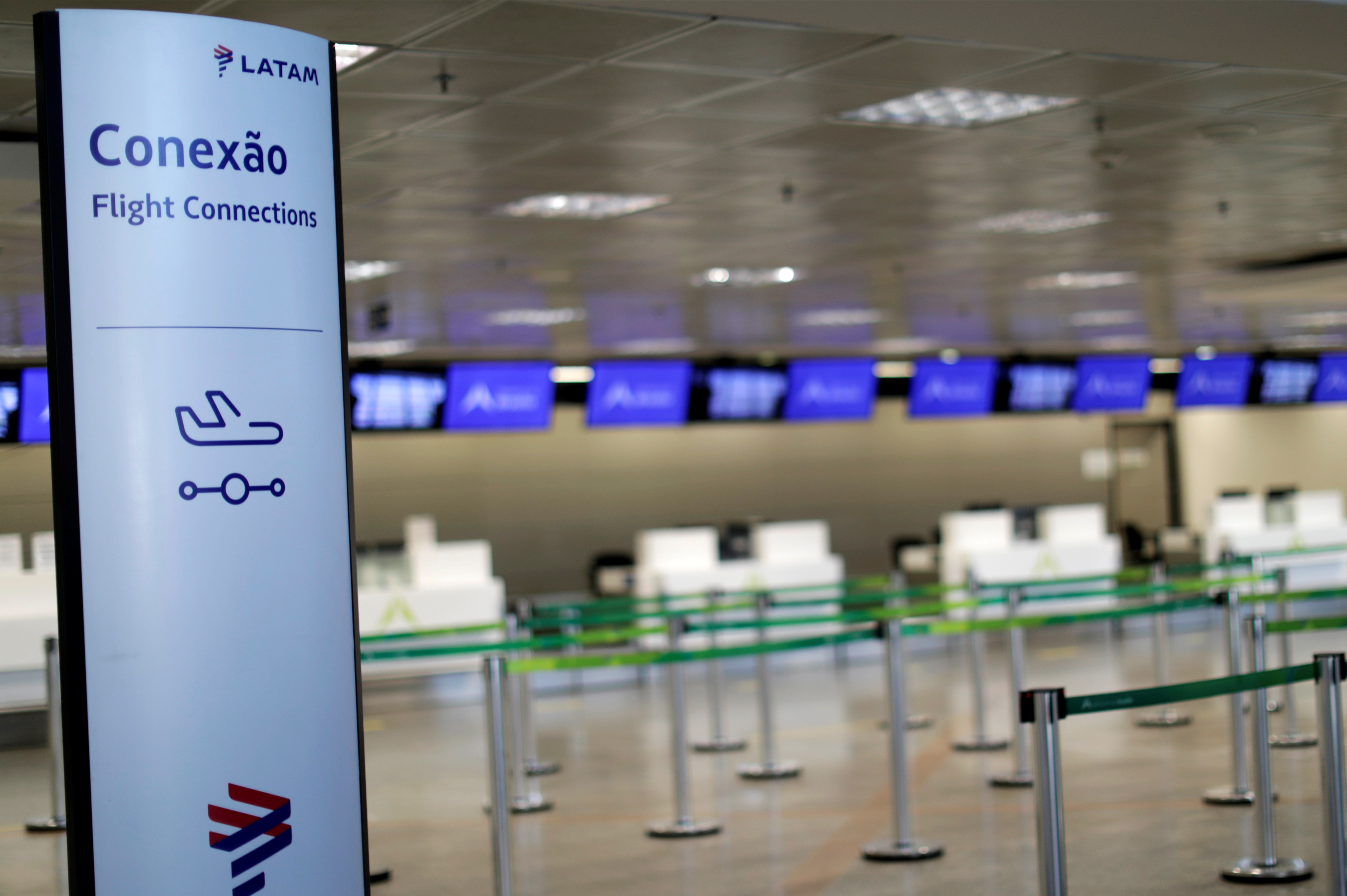 A banner of Latam Airlines is seen next to empty check-in counters in Brasilia International Airport as air traffic is affected by the outbreak of the coronavirus disease (COVID-19), in Brasilia, Brazil May 28, 2020. REUTERS/Ueslei Marcelino