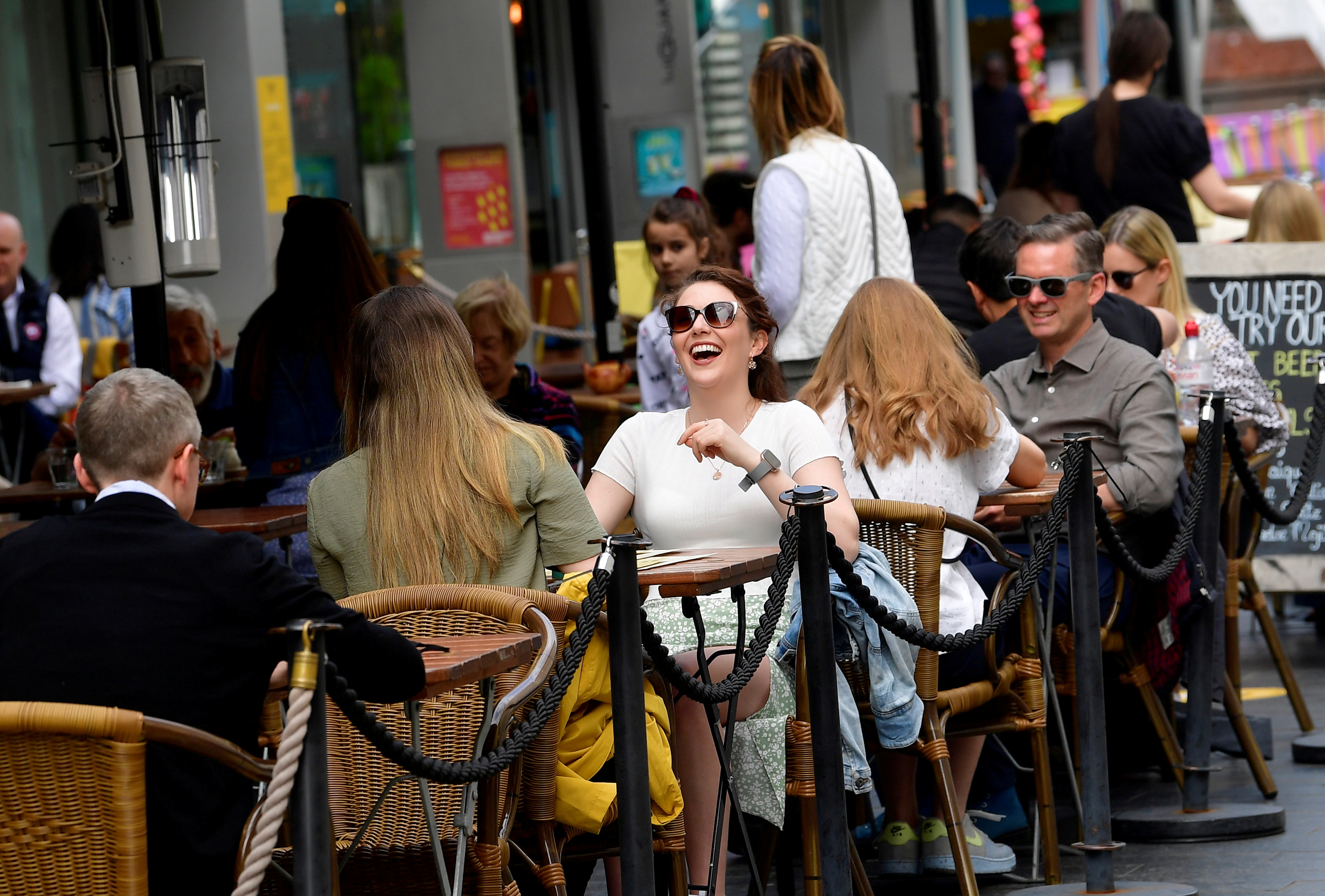 People relax at outdoor dining areas as lockdown restrictions continue to ease in London