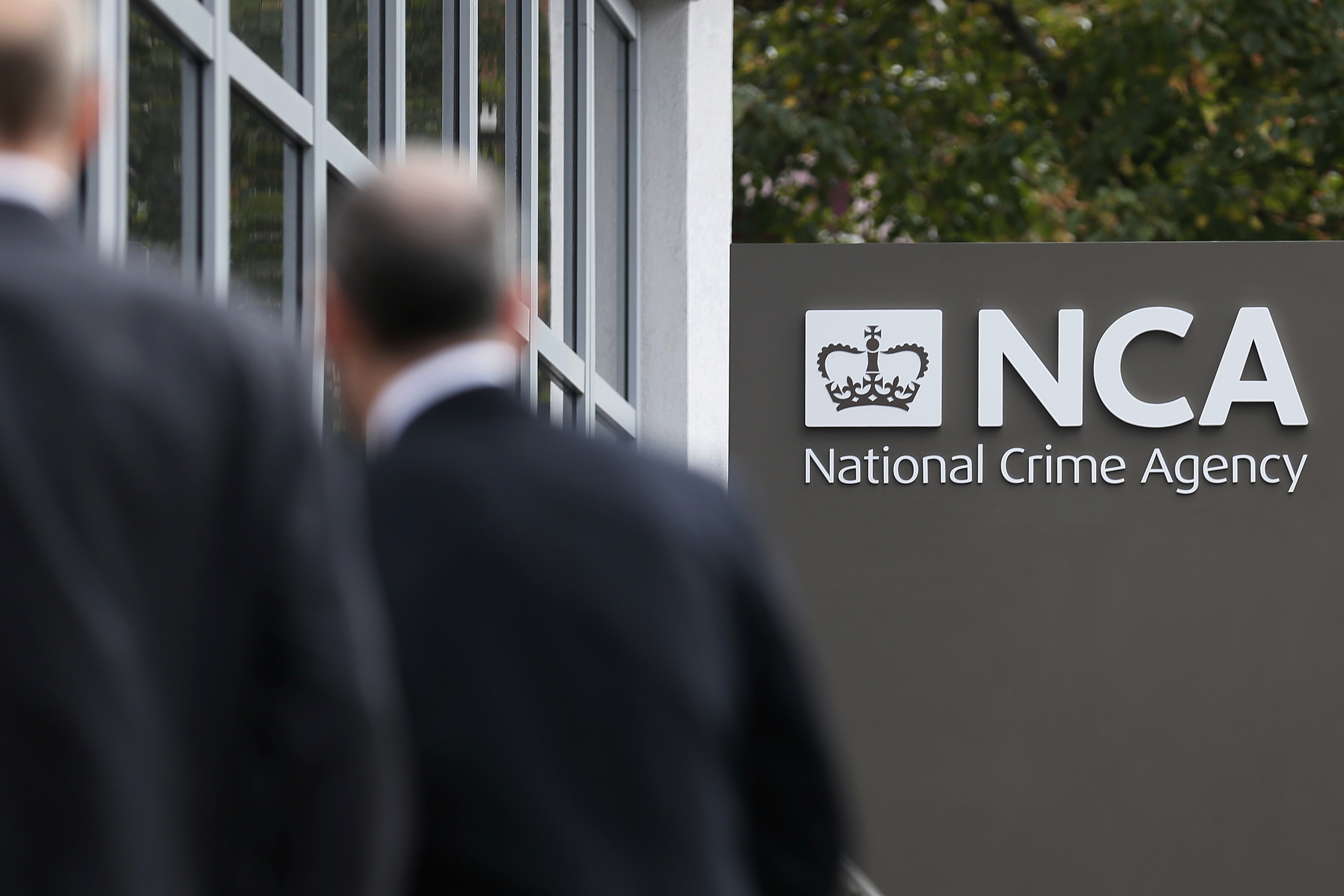 Pedestrians walk past the National Crime Agency headquarters in London