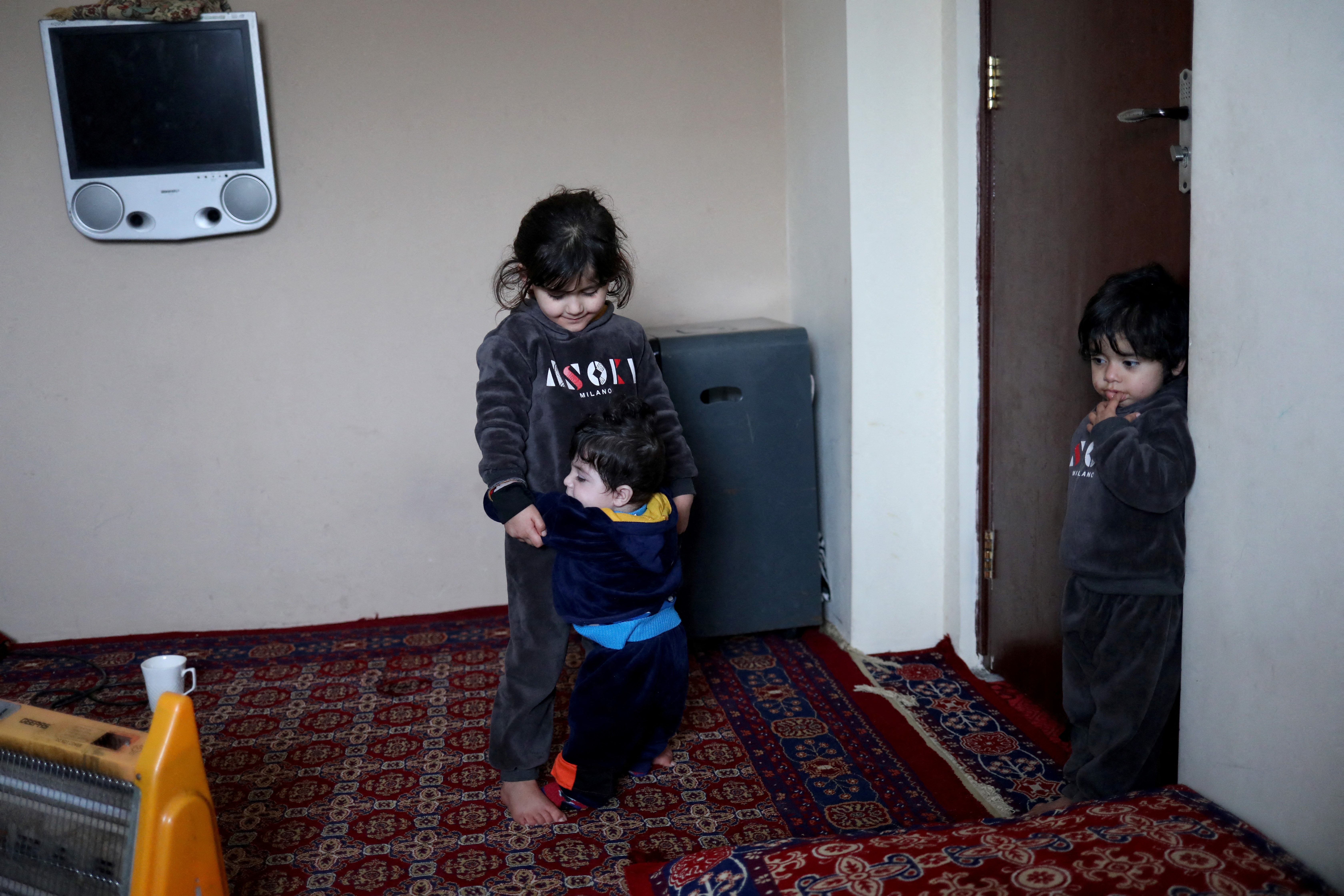 Kaenat Safi, daughetr of Hamid Safi plays with baby Sohail Ahmadi at her home in Kabul