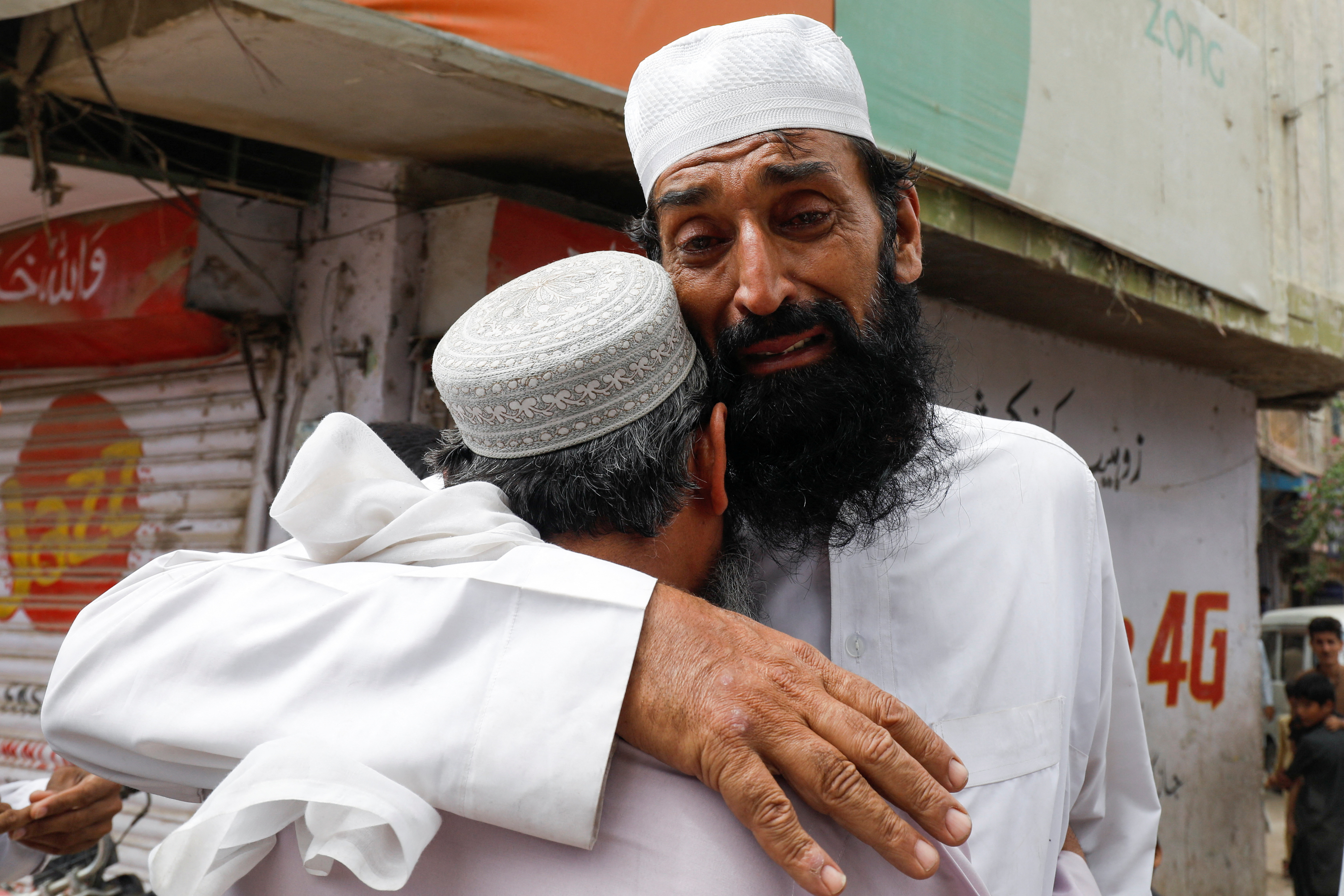 Umer Zada, father of seven year-old Saad Umer, who was killed with others in a stampede during handout distribution, mourns the death of his son during the funeral in Karachi