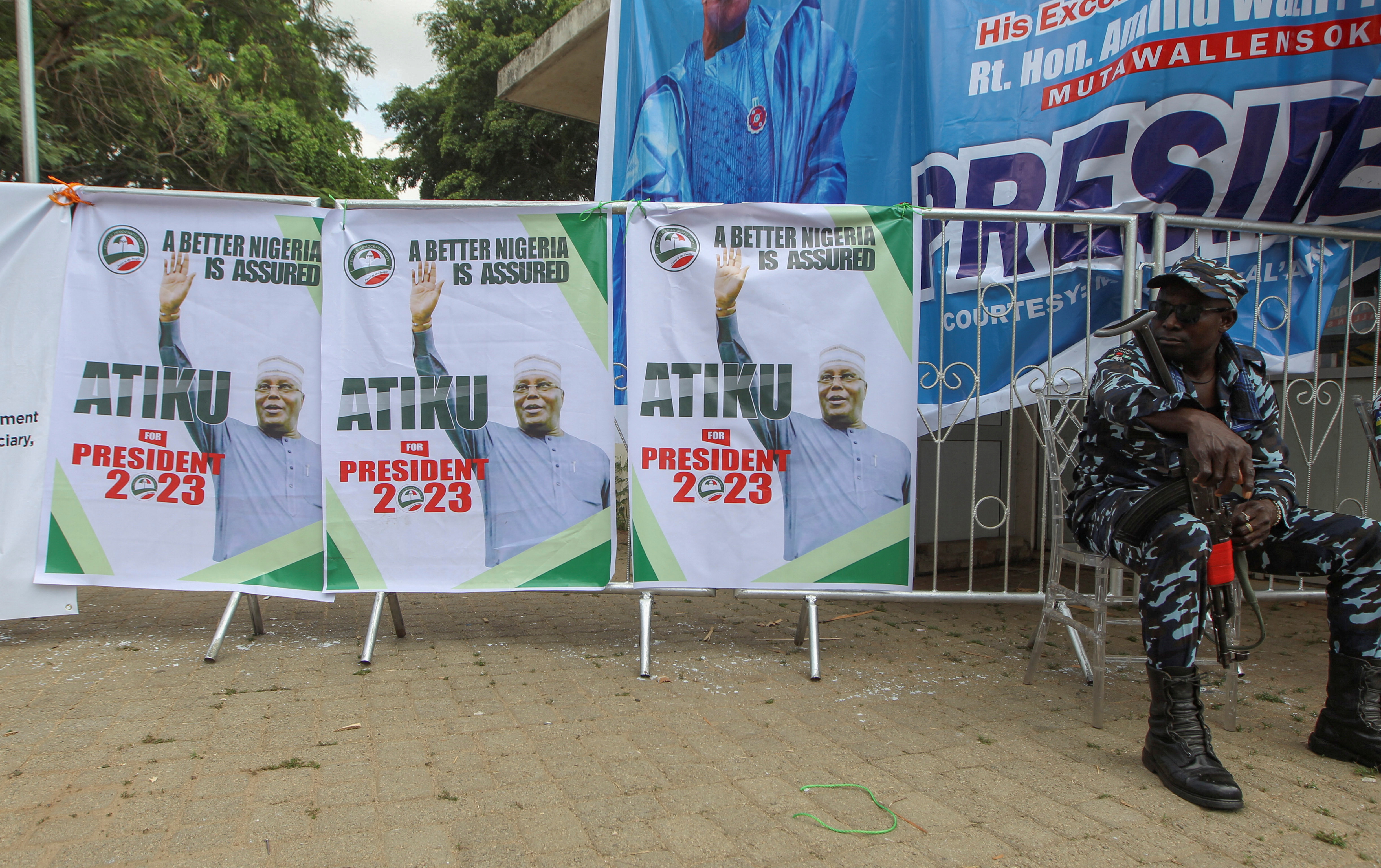 A police man looks at Posters of Former Nigeria Vice president Atiku Abubakar at the National convention centre in Abuja