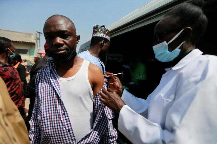 A man receives a COVID-19 vaccine at Wuse market, in Abuja