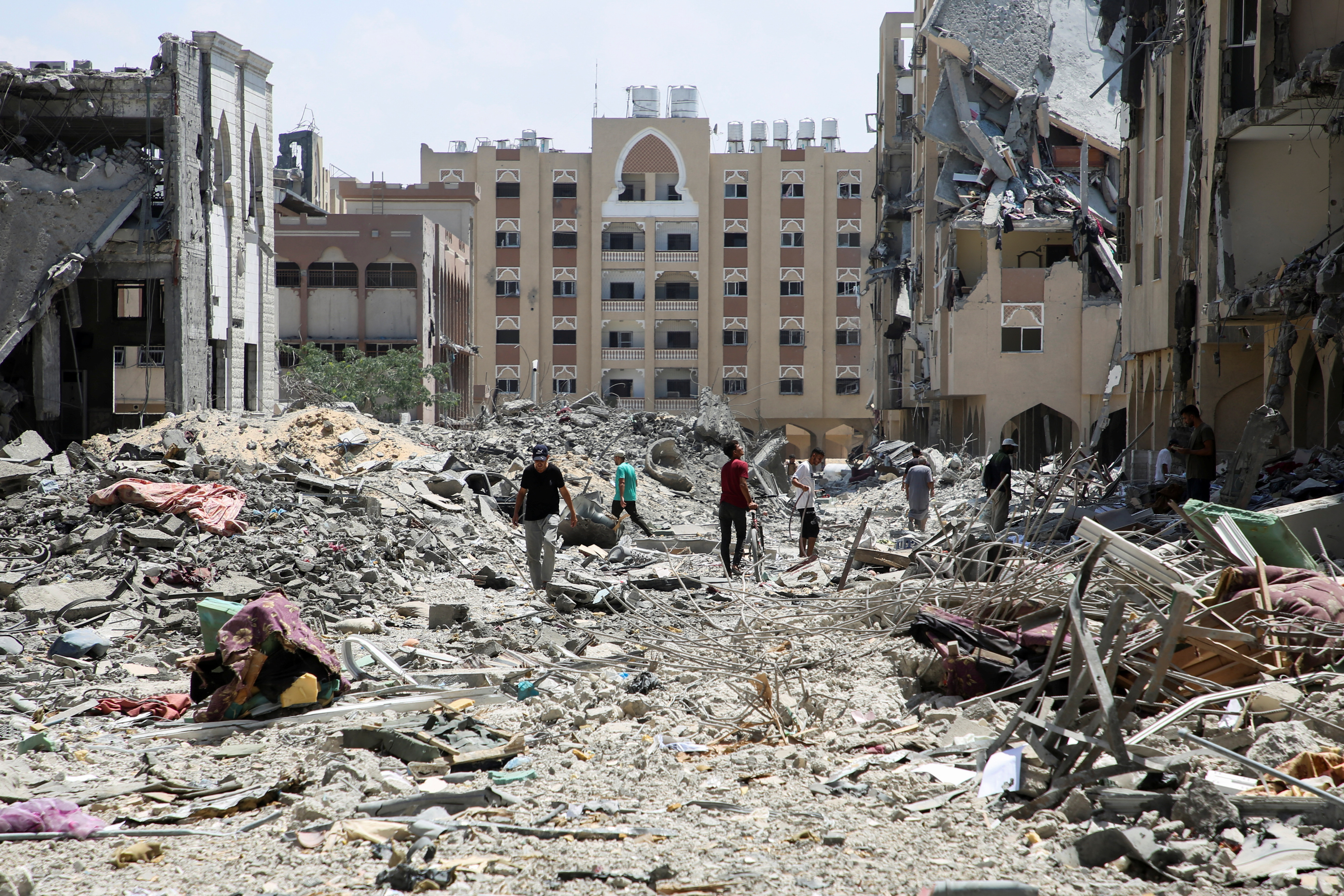 Palestinians inspect damage in Qatari-funded Hamad City, in Khan Younis