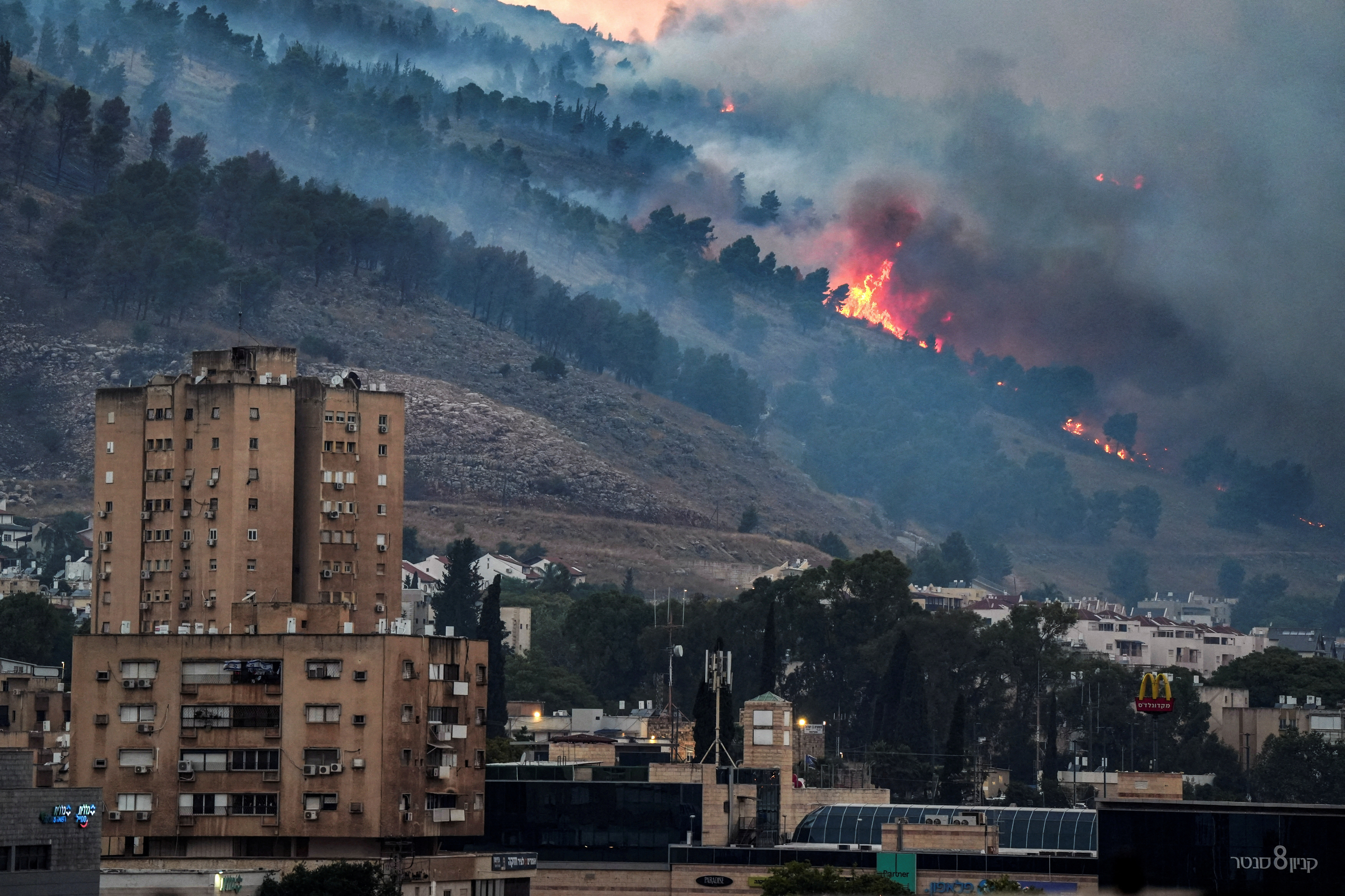 Smoke and fire covers the area following rocket attacks from Lebanon near Kiryat Shmona