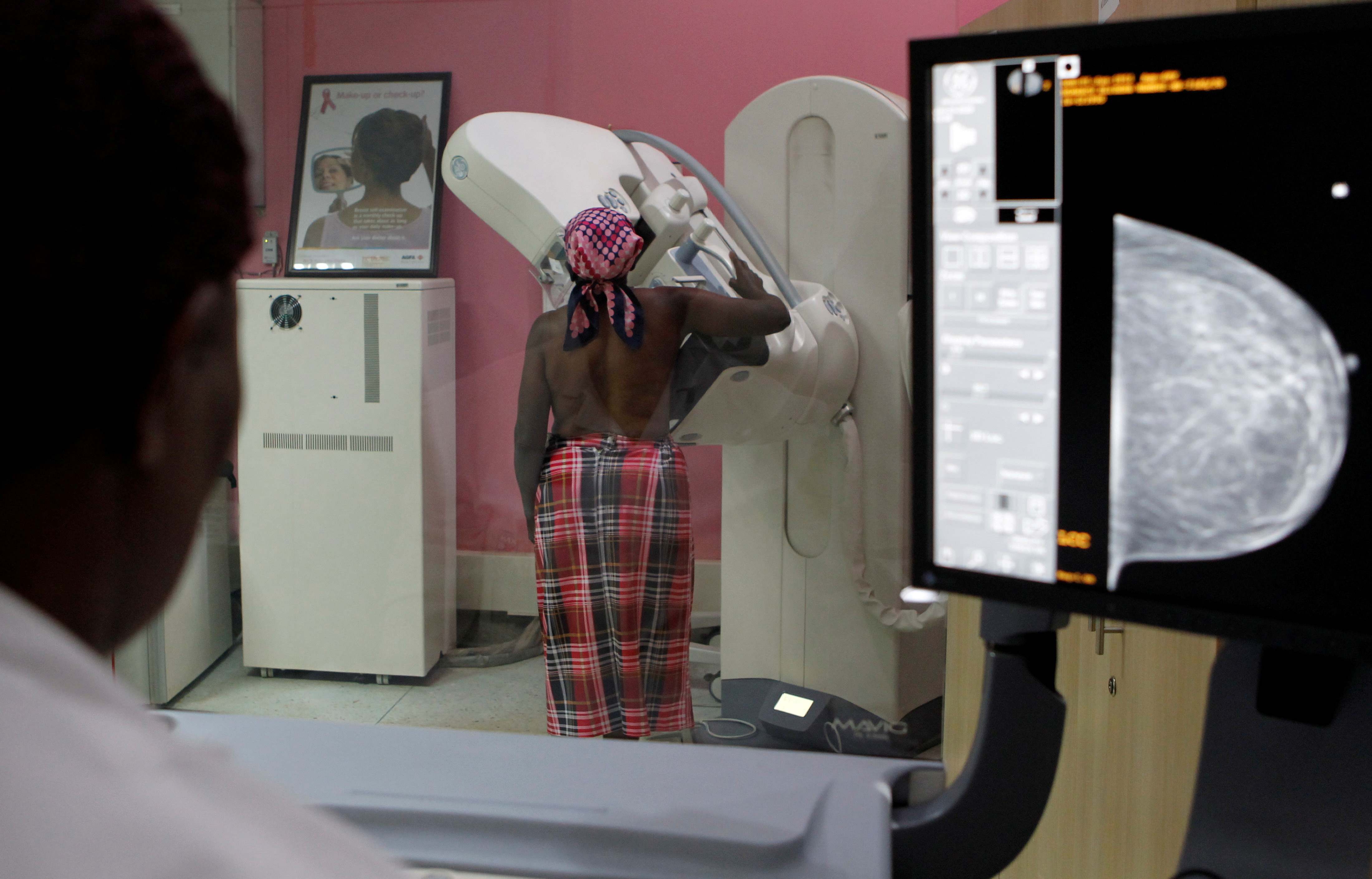 A patient is seen through the glass as she undergoes a mammogram X-ray picture of the breast to look for early signs of breast cancer in the radiology unit at the Kenyatta National Hospital in Nairobi