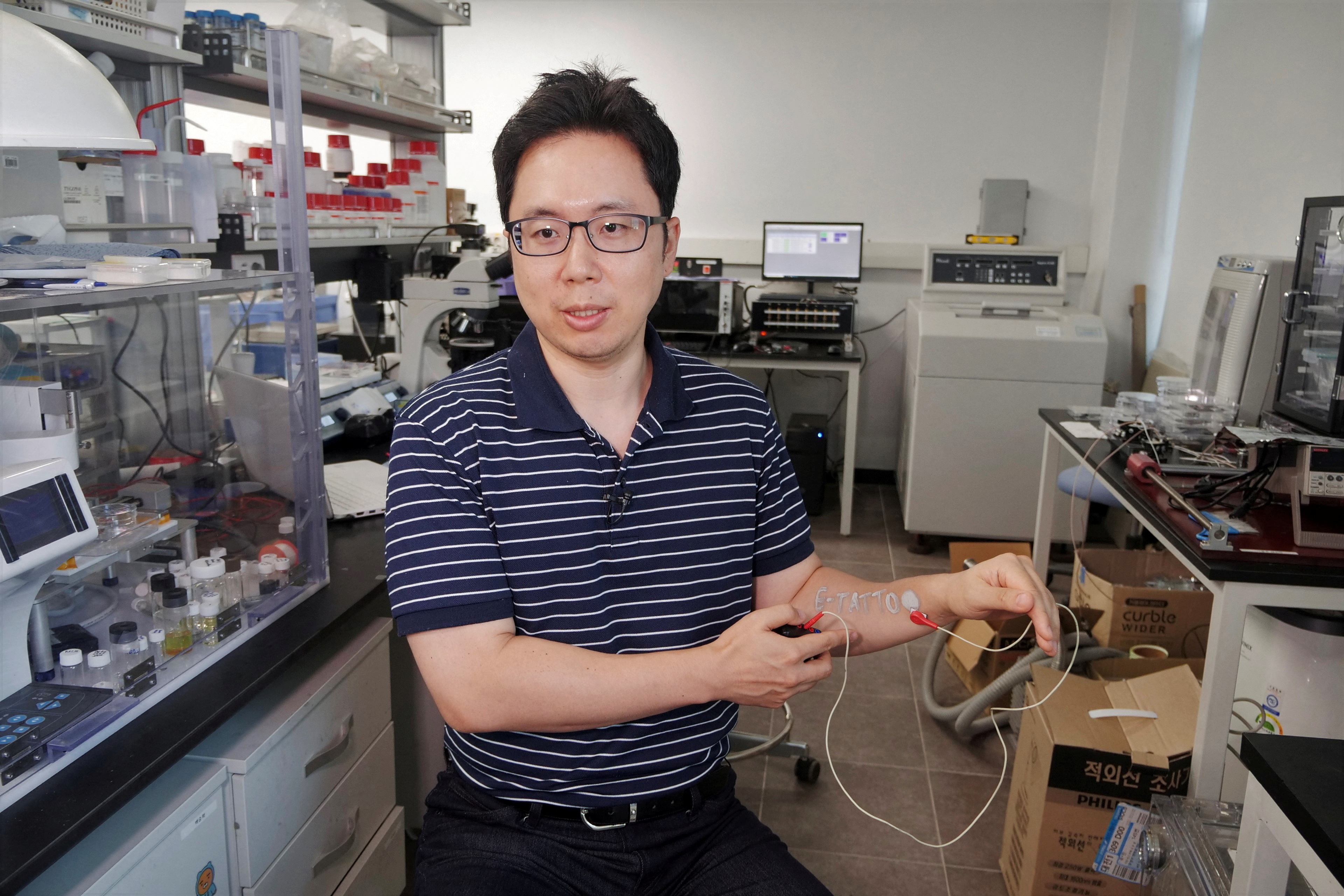 Steve Park, Materials Science & Engineering professor at Korea Advanced Institute of Science and Technology (KAIST), demonstrates an electronic tattoo (e-tattoo) on his arm connected with an electrocardiogram (ECG) monitoring system in Daejeon