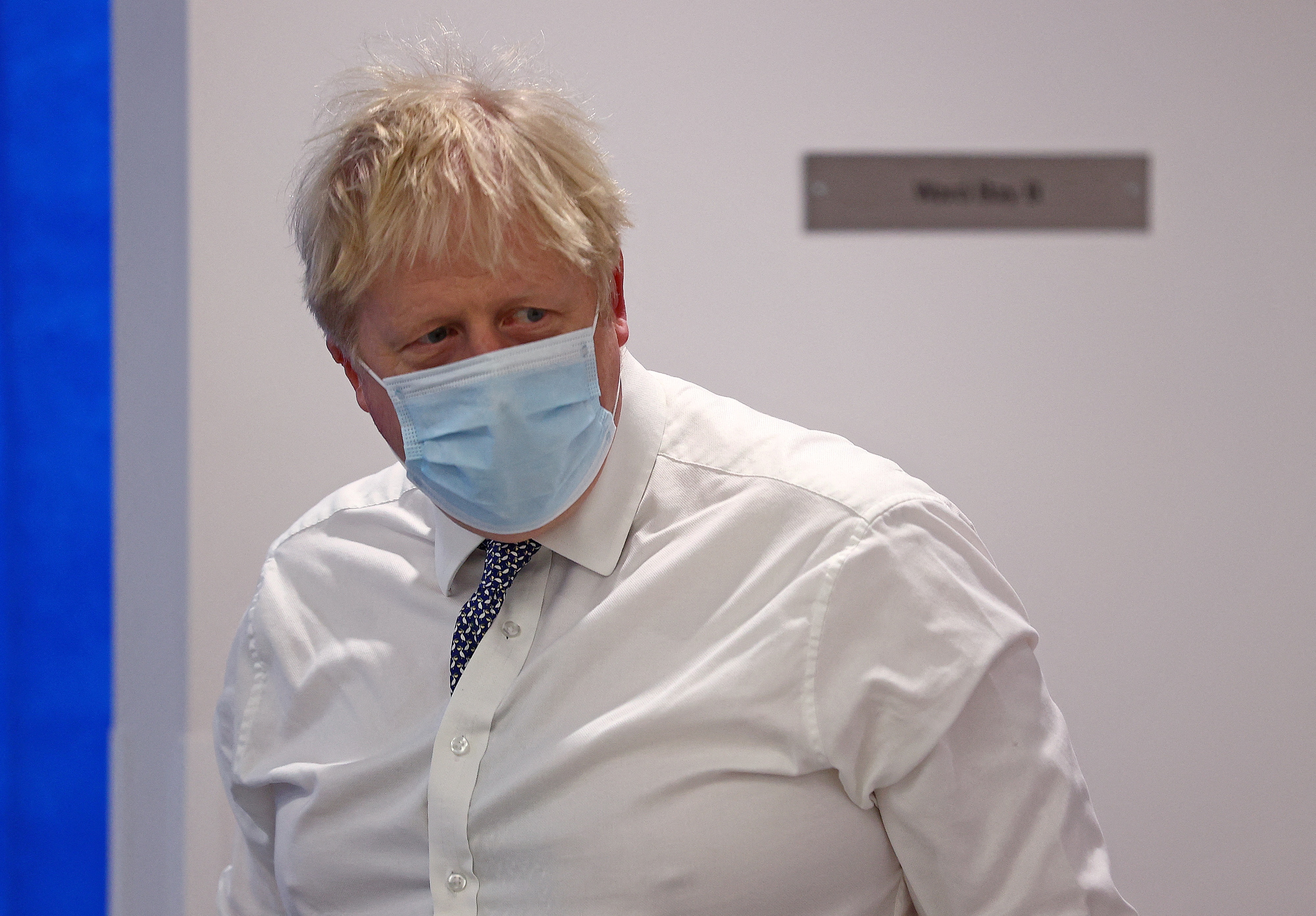Britain's Prime Minister Boris Johnson wearing a face covering to help mitigate the spread of Covid-19, reacts during his visit to Milton Keynes University Hospital, north of London, Britain January 24, 2022. Adrian Dennis/Pool via REUTERS
