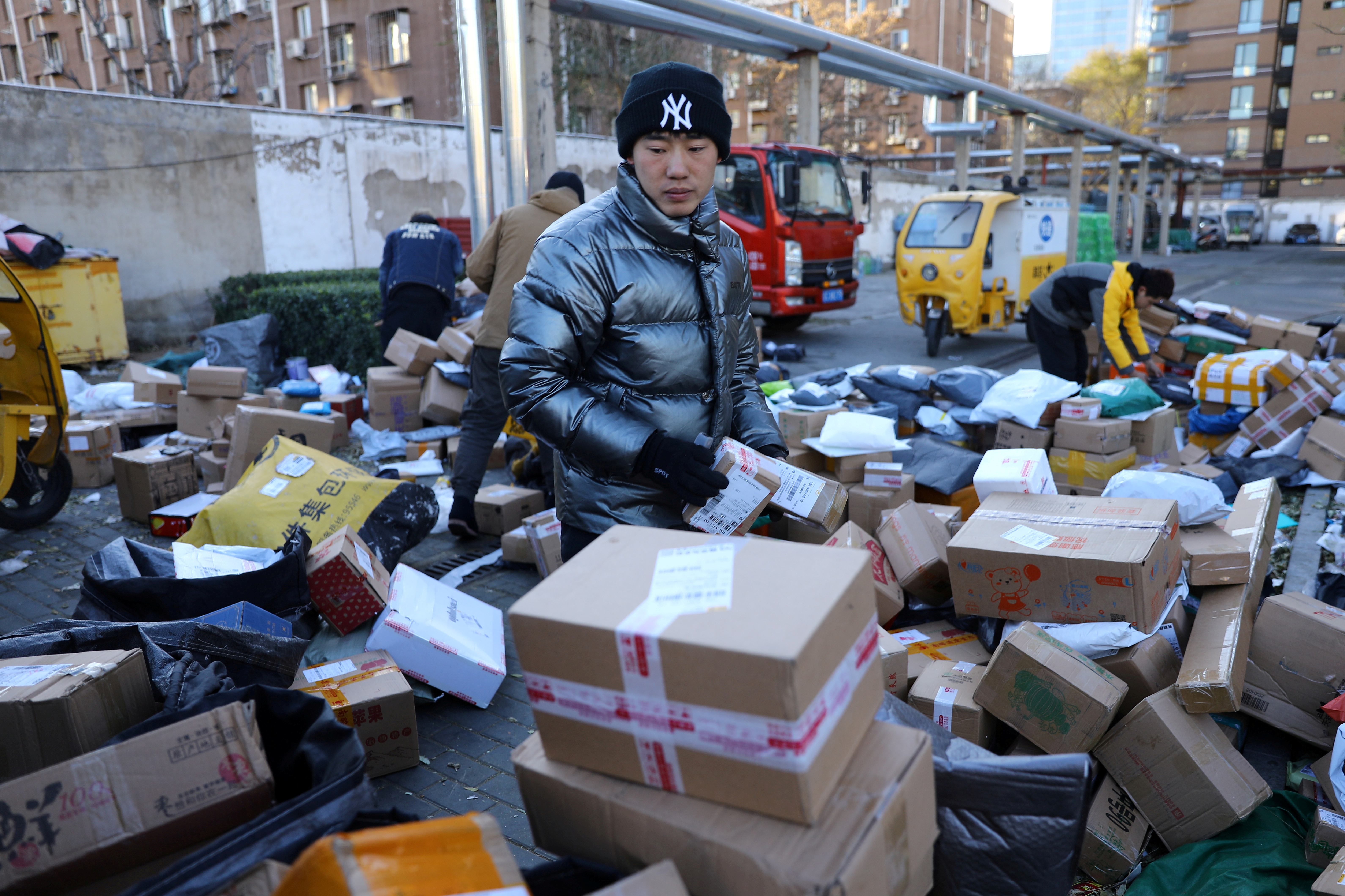 Delivery workers sort parcels at a makeshift logistics station during Singles’ Day shopping festival in Beijing