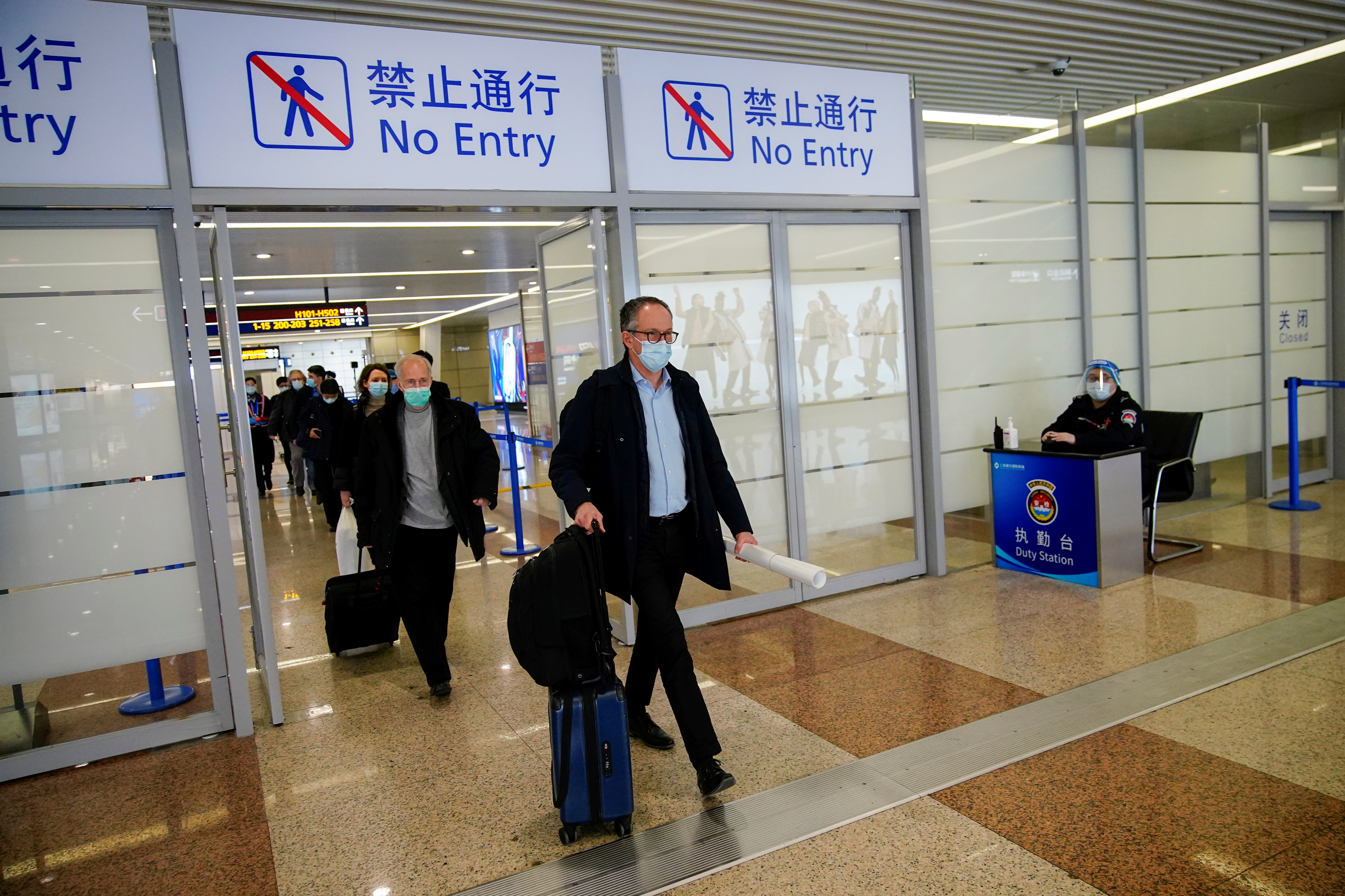 Members of the World Health Organisation (WHO) arrive at the airport in Shanghai