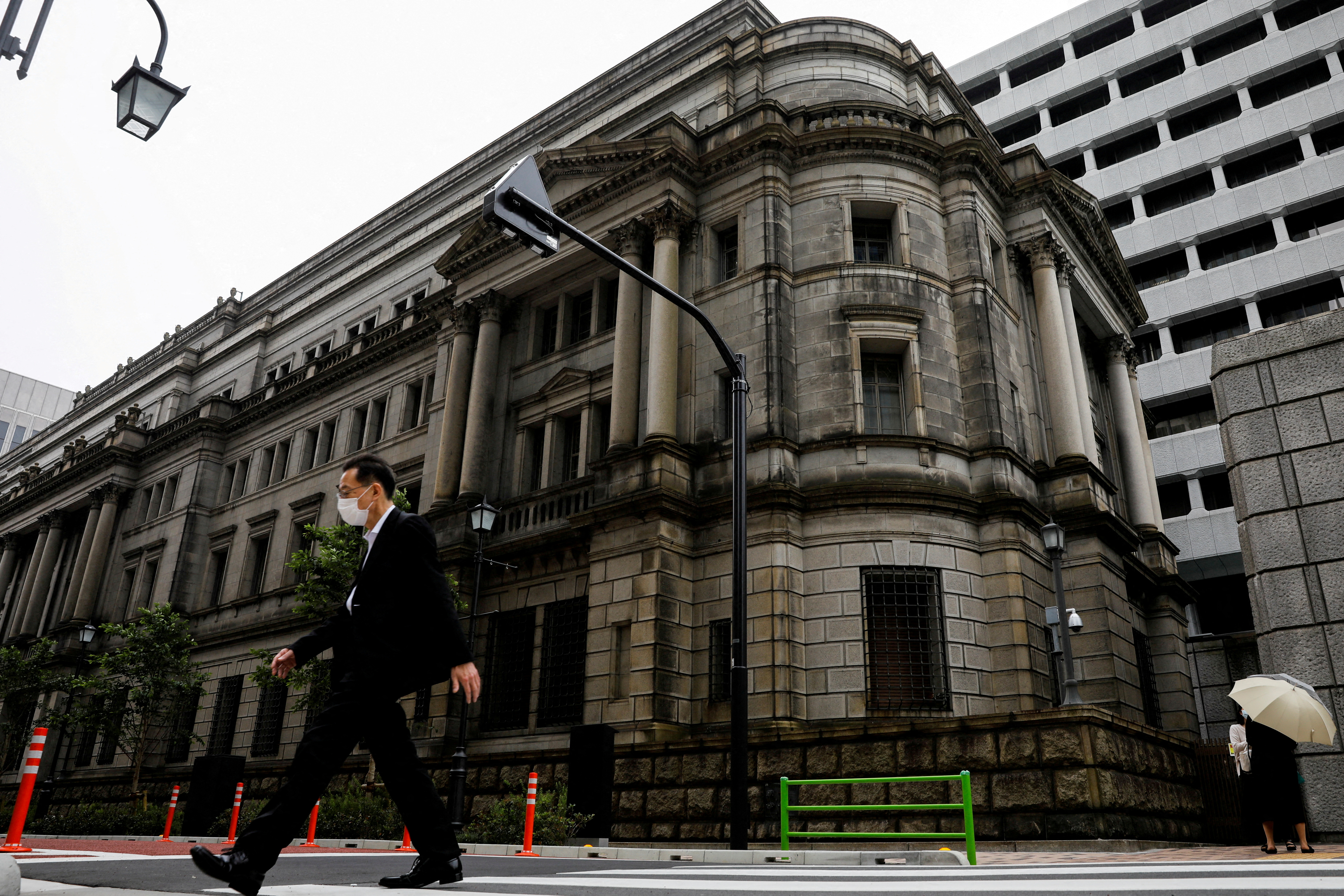 A man wearing a protective mask walks past the headquarters of Bank of Japan amid the coronavirus disease (COVID-19) outbreak in Tokyo, Japan, May 22, 2020. REUTERS/Kim Kyung-Hoon