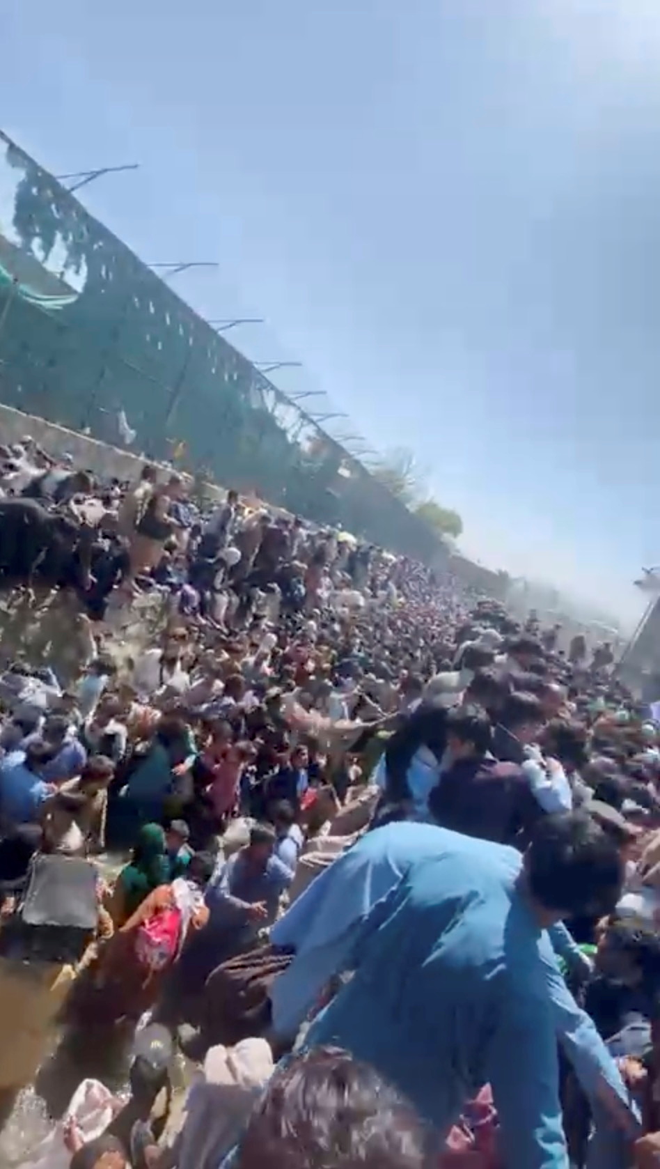 People are crowded before Thursday's attack, along a canal near the Abbey Gate at Kabul's airport, Afghanistan August 26, 2021 in this still grab obtained by REUTERS from a video. 