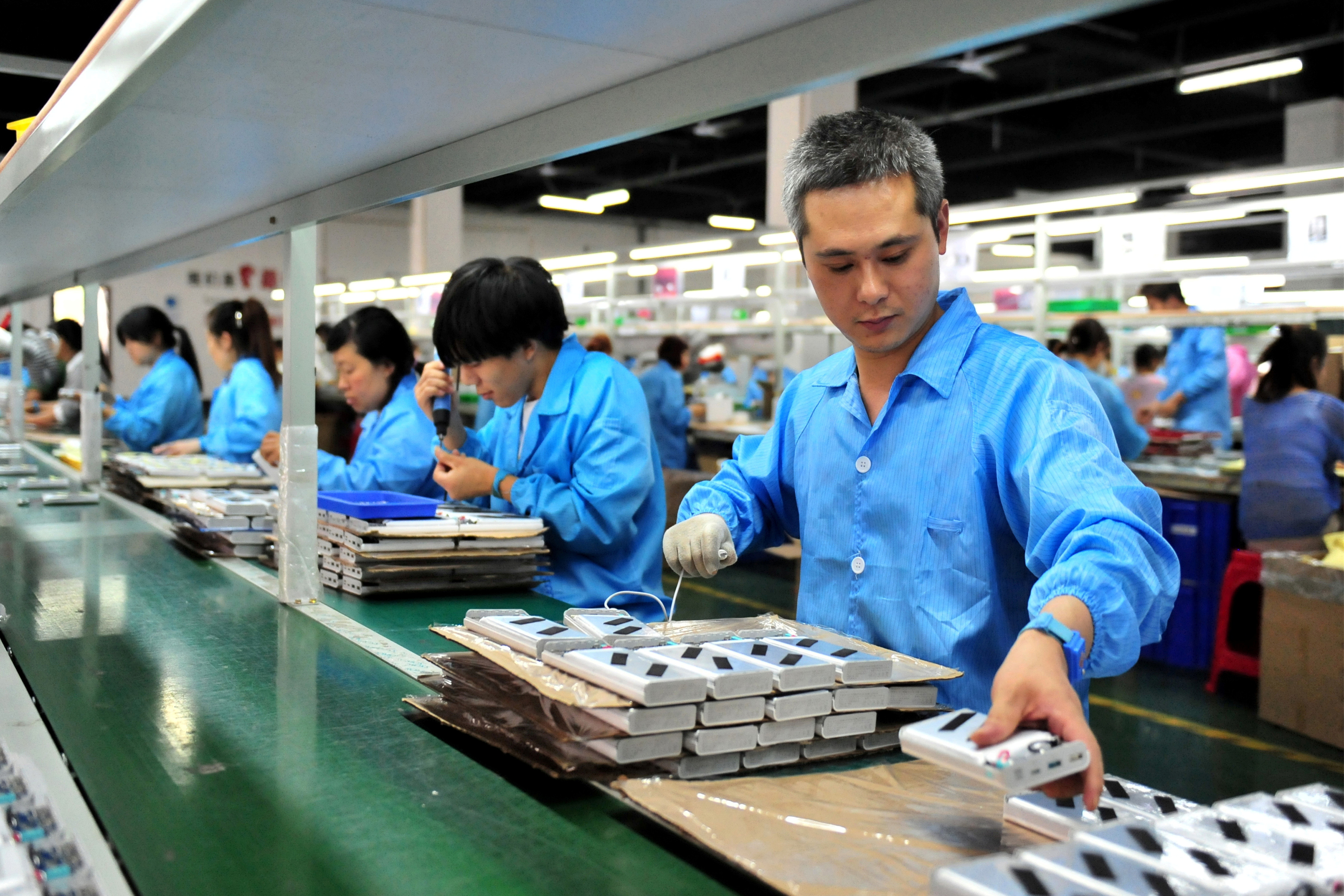 Employees work on a production line manufacturing lithium battery products at a factory in Yichang, Hubei