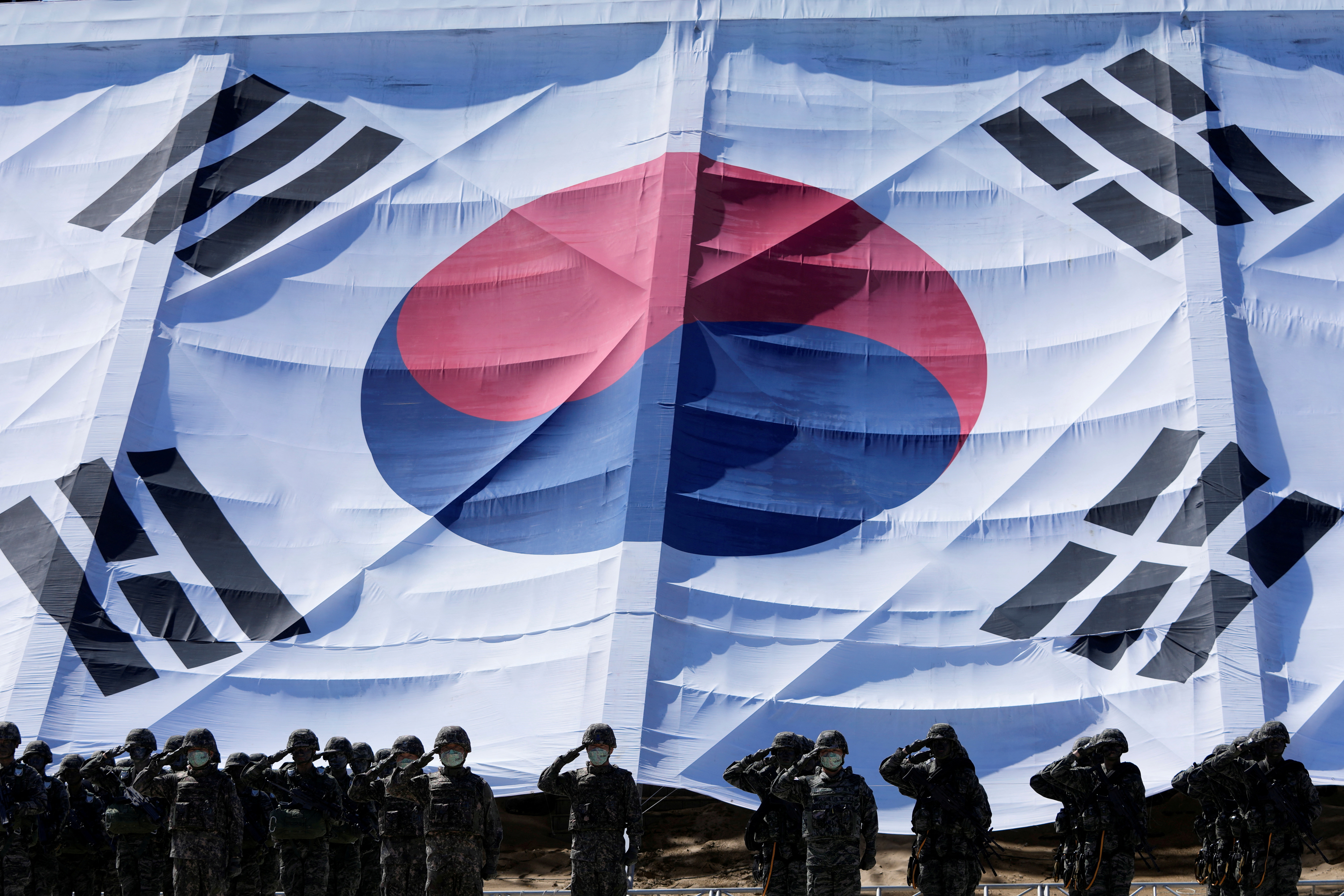 South Korean soldiers salute in front of a huge national flag during media day for the 73rd anniversary of the Armed Forces Day, which falls on October 1, in Pohang, South Korea, September 30