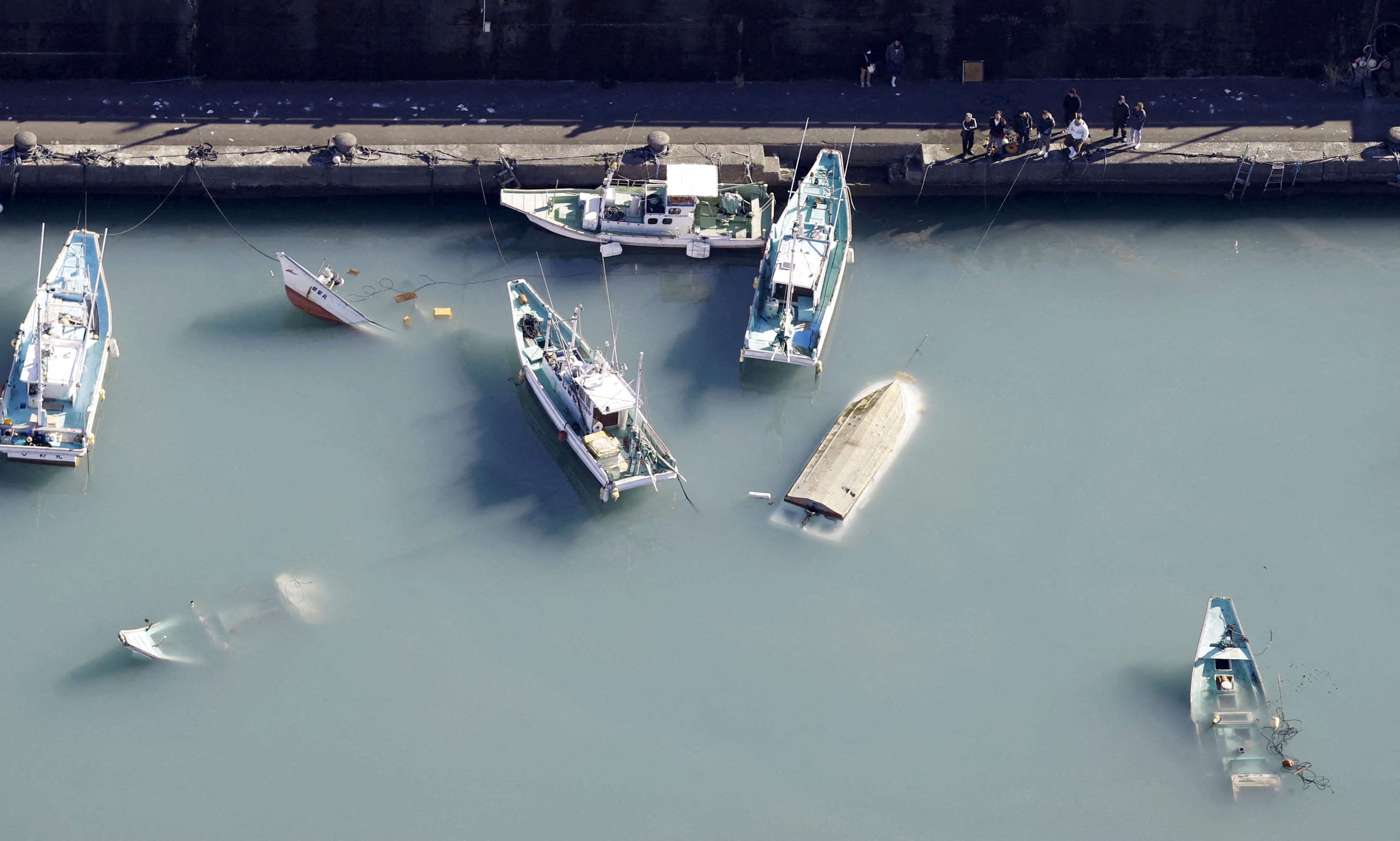 An aerial view shows capsized boats believed to be affected by the tsunami caused by an underwater volcano eruption on the island of Tonga at the South Pacific, in Muroto, Japan