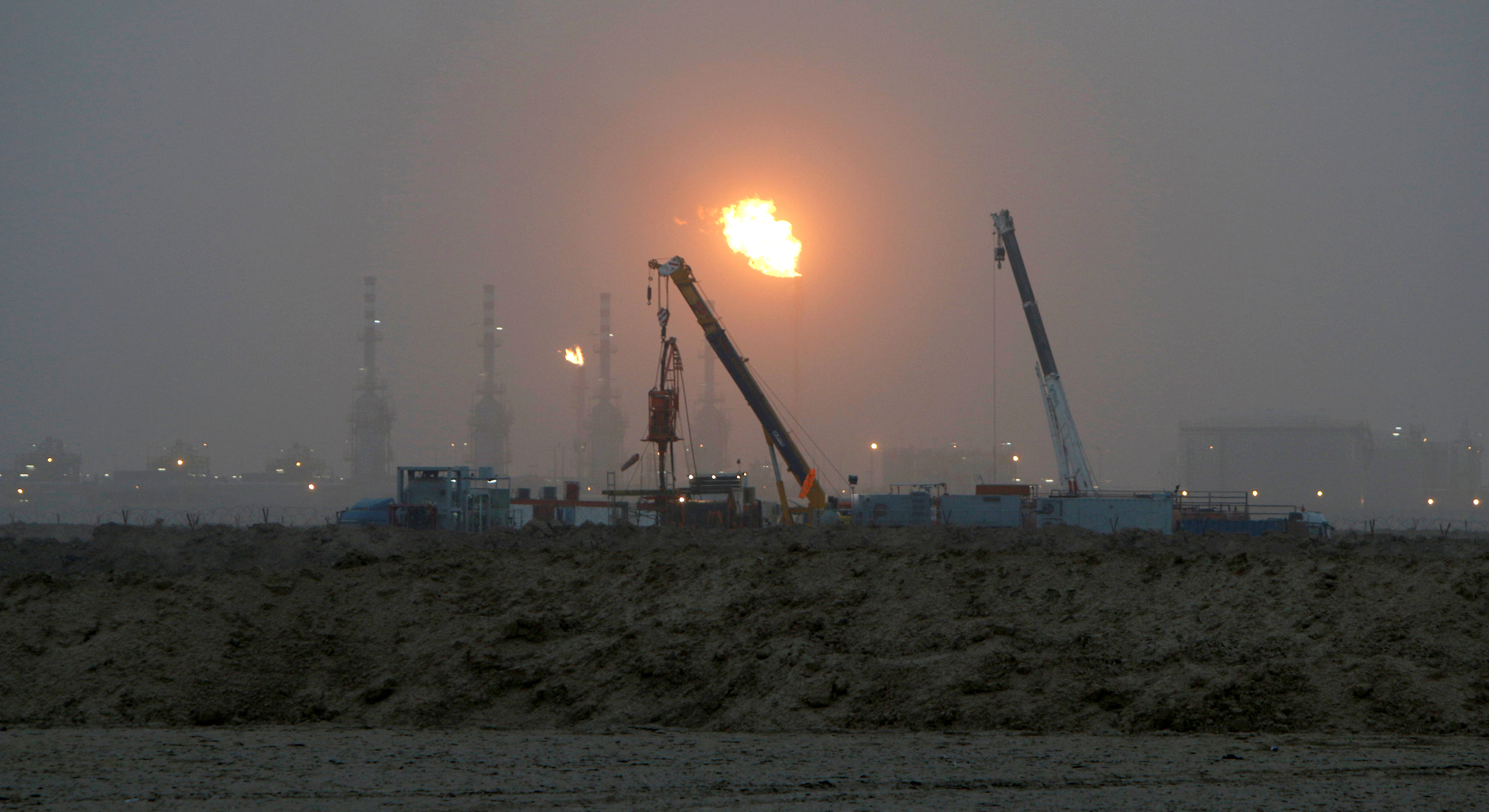 Flames emerge from a pipeline at the oil fields in Basra, southeast of Baghdad