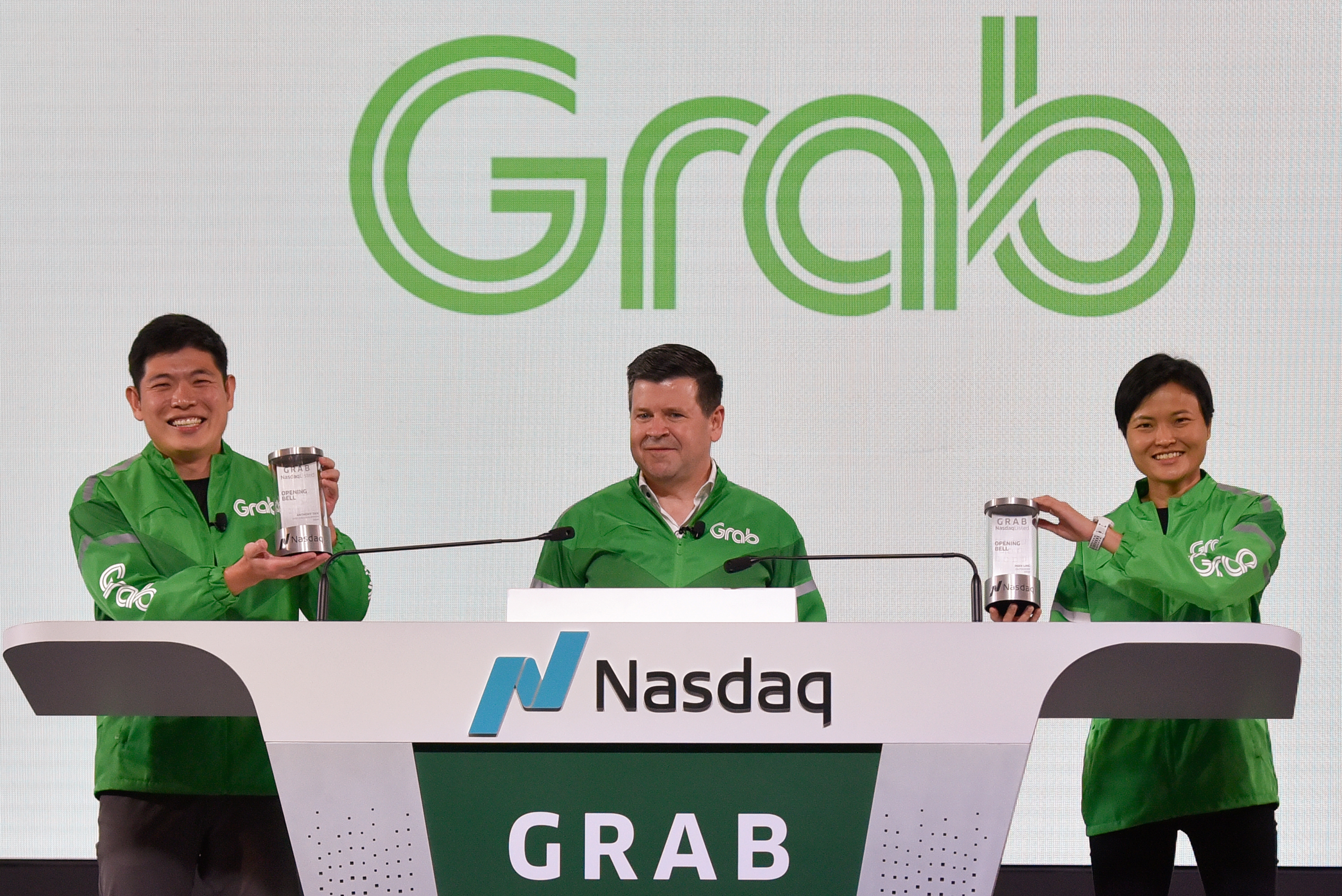 Grab's CEO Anthony Tan and co-founder Tan Hooi Ling hold up the Nasdaq Crystal at the Grab Bell Ringing Ceremony in Singapore