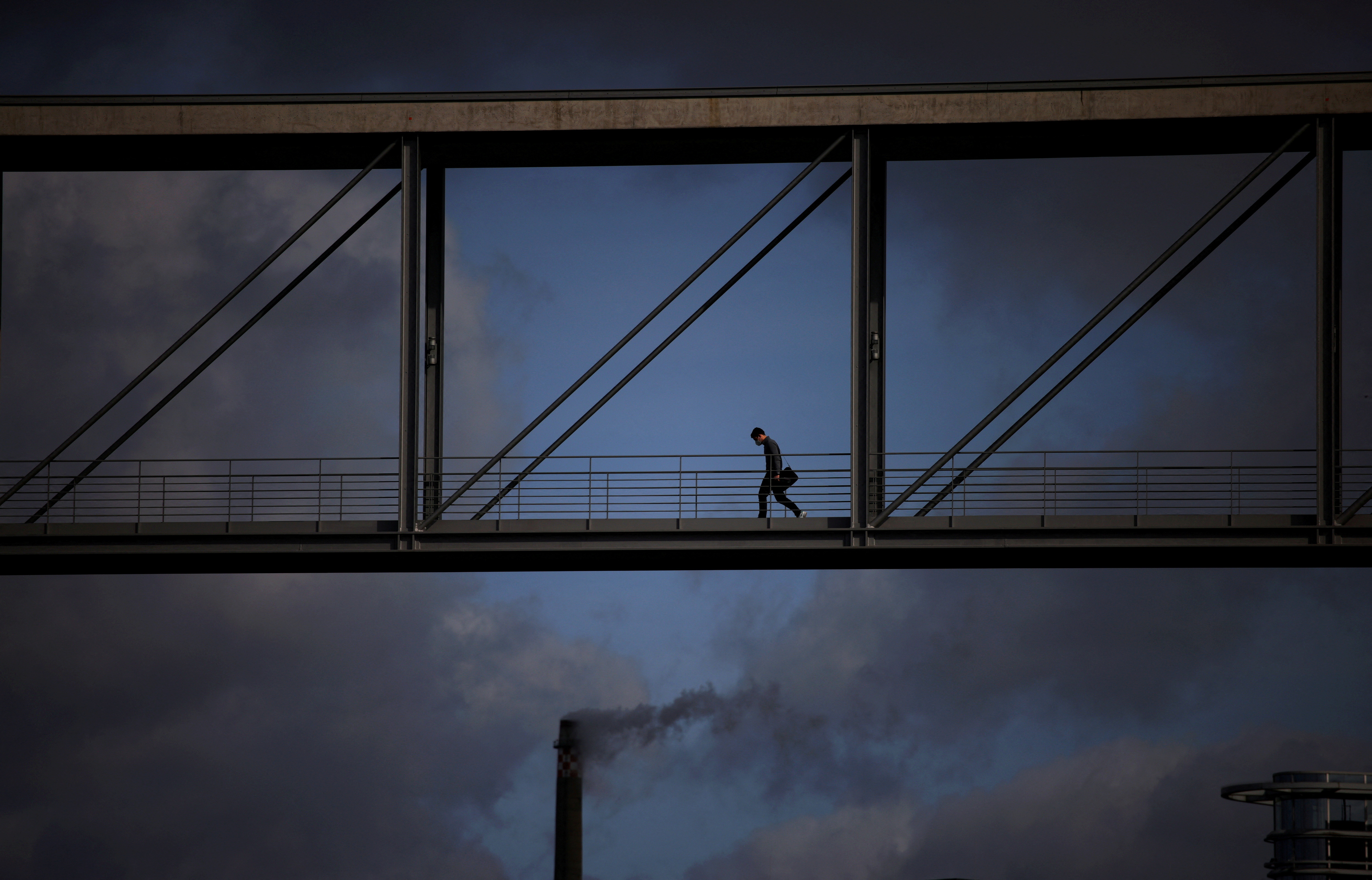 A person crosses a bridge between the buildings of Germany's Bundestag