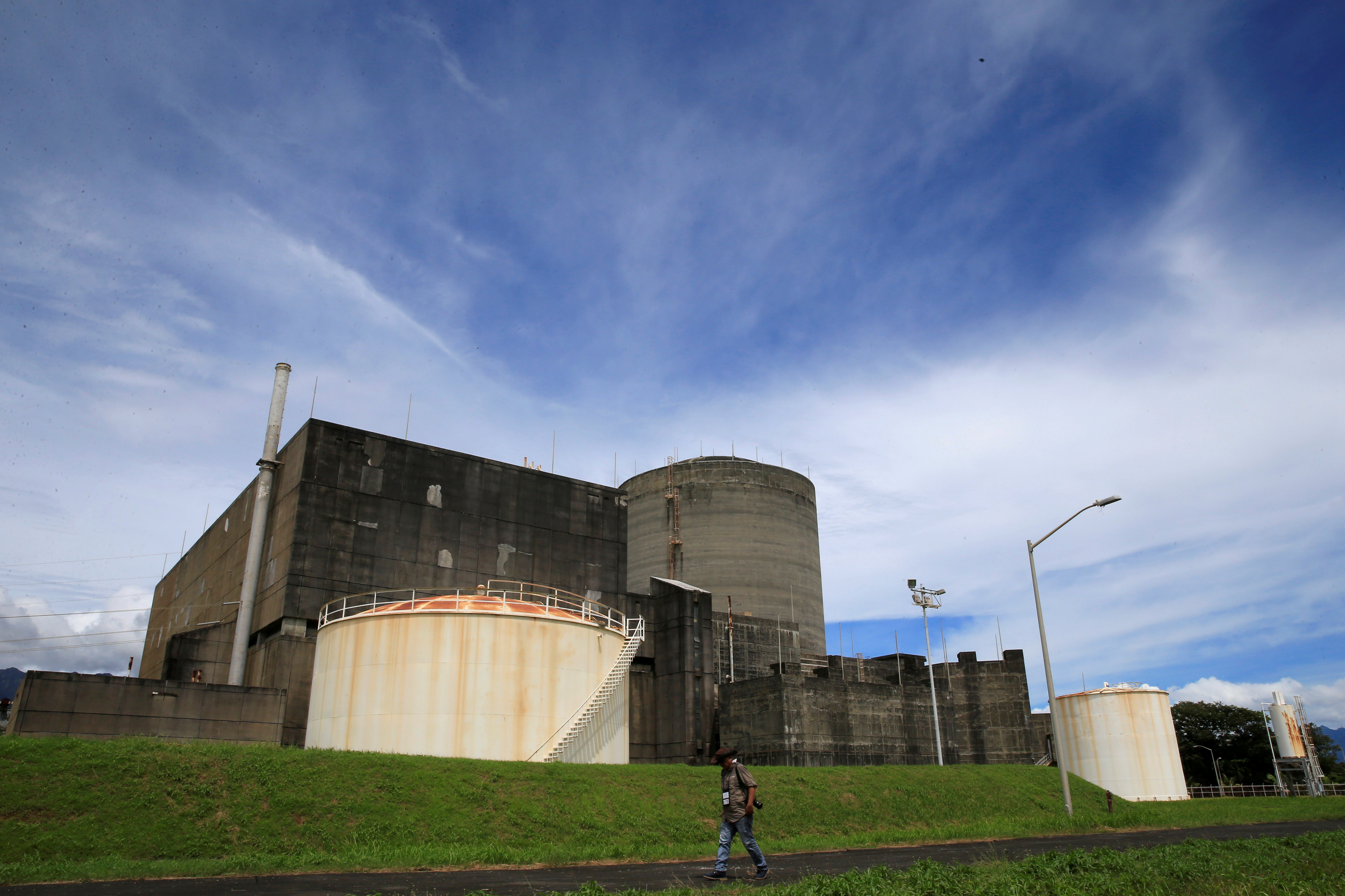 FILE PHOTO - A local photographer walks past the Bataan Nuclear Power Plant during a media tour around the BNPP compound in Morong town, Bataan province, Philippines