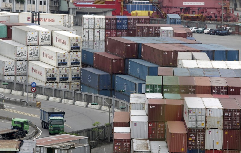 Trucks drive near containers at Keelung port, northern Taiwan, October 30, 2015.  REUTERS/Pichi Chuang/File Photo