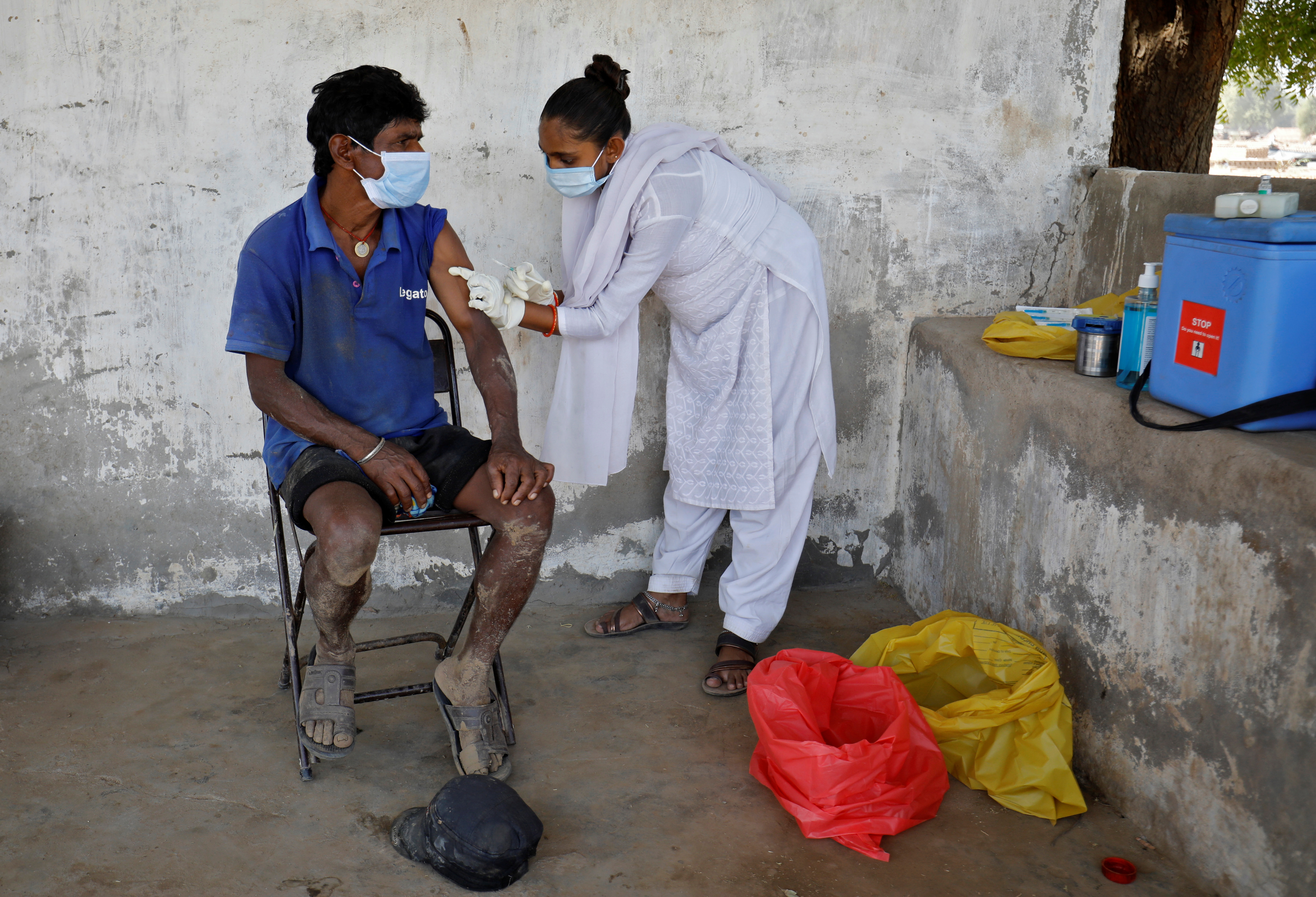A brick kiln worker receives a dose of COVISHIELD, a coronavirus disease (COVID-19) vaccine manufactured by Serum Institute of India, at Kavitha village on the outskirts of Ahmedabad, India, April 8, 2021. REUTERS/Amit Dave