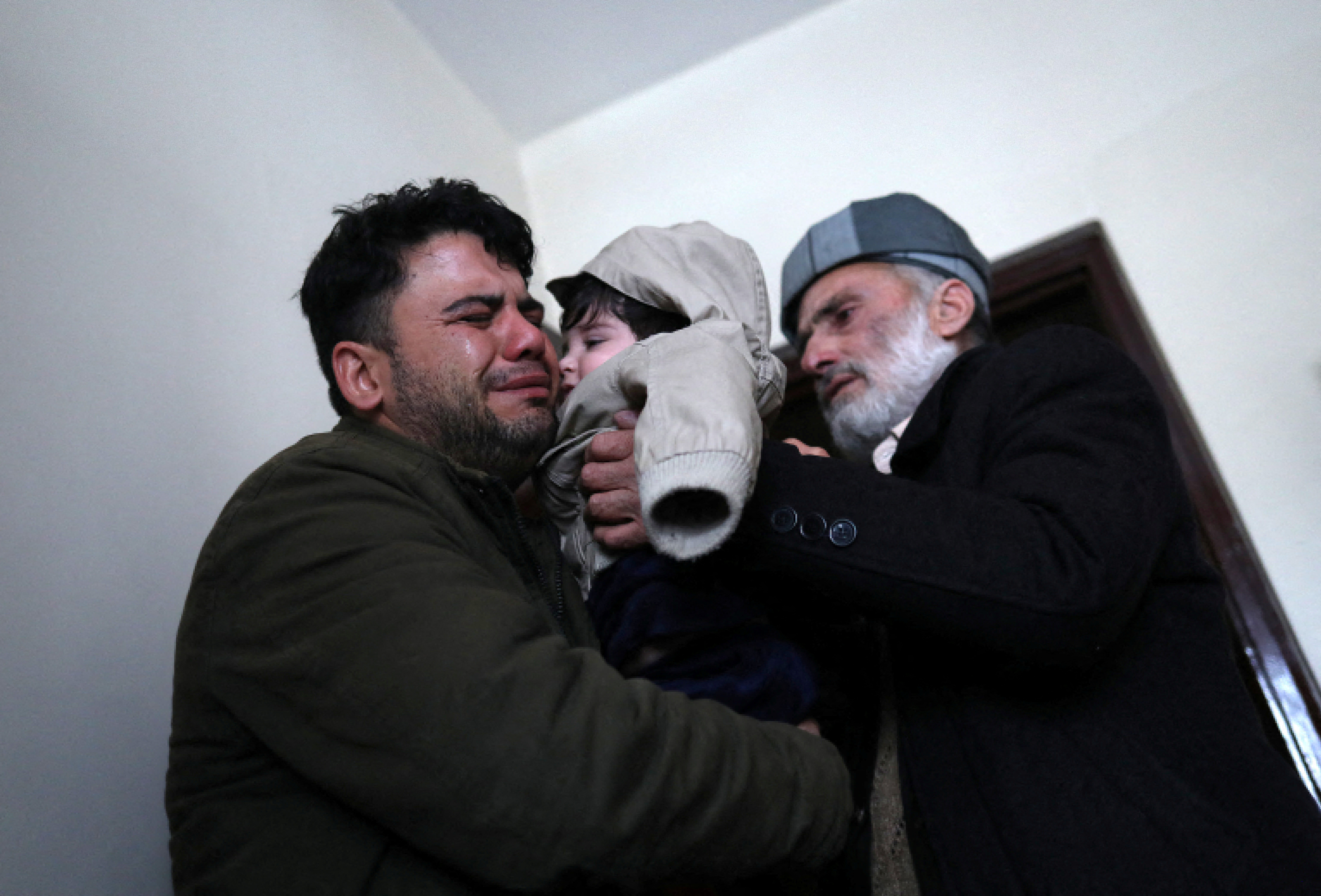 Hamid Safi cries as he hands over Sohail to his grandfather Mohammad Qasem Razawi in Kabul