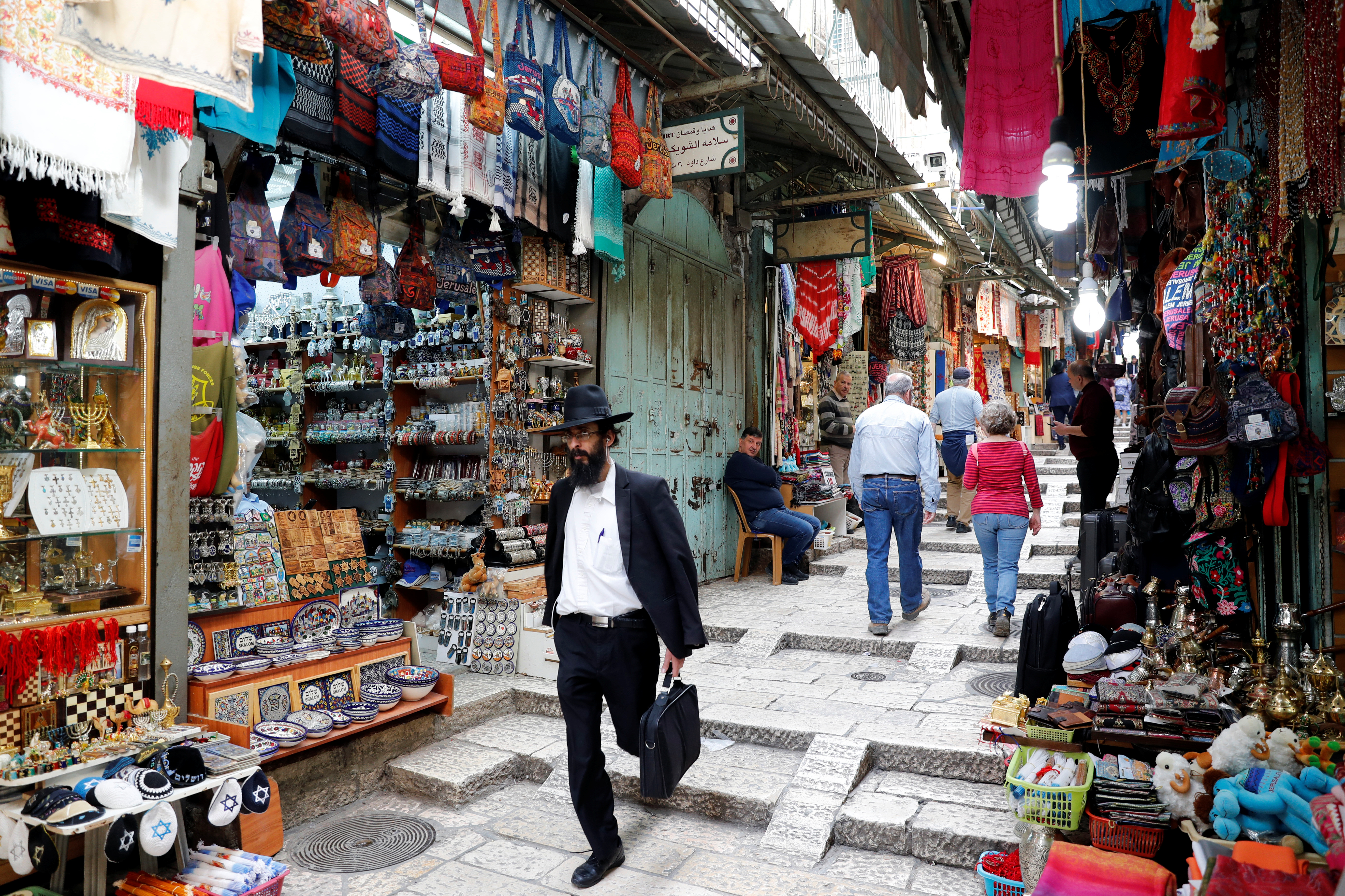 People walk around an alley in Jerusalem's Old City