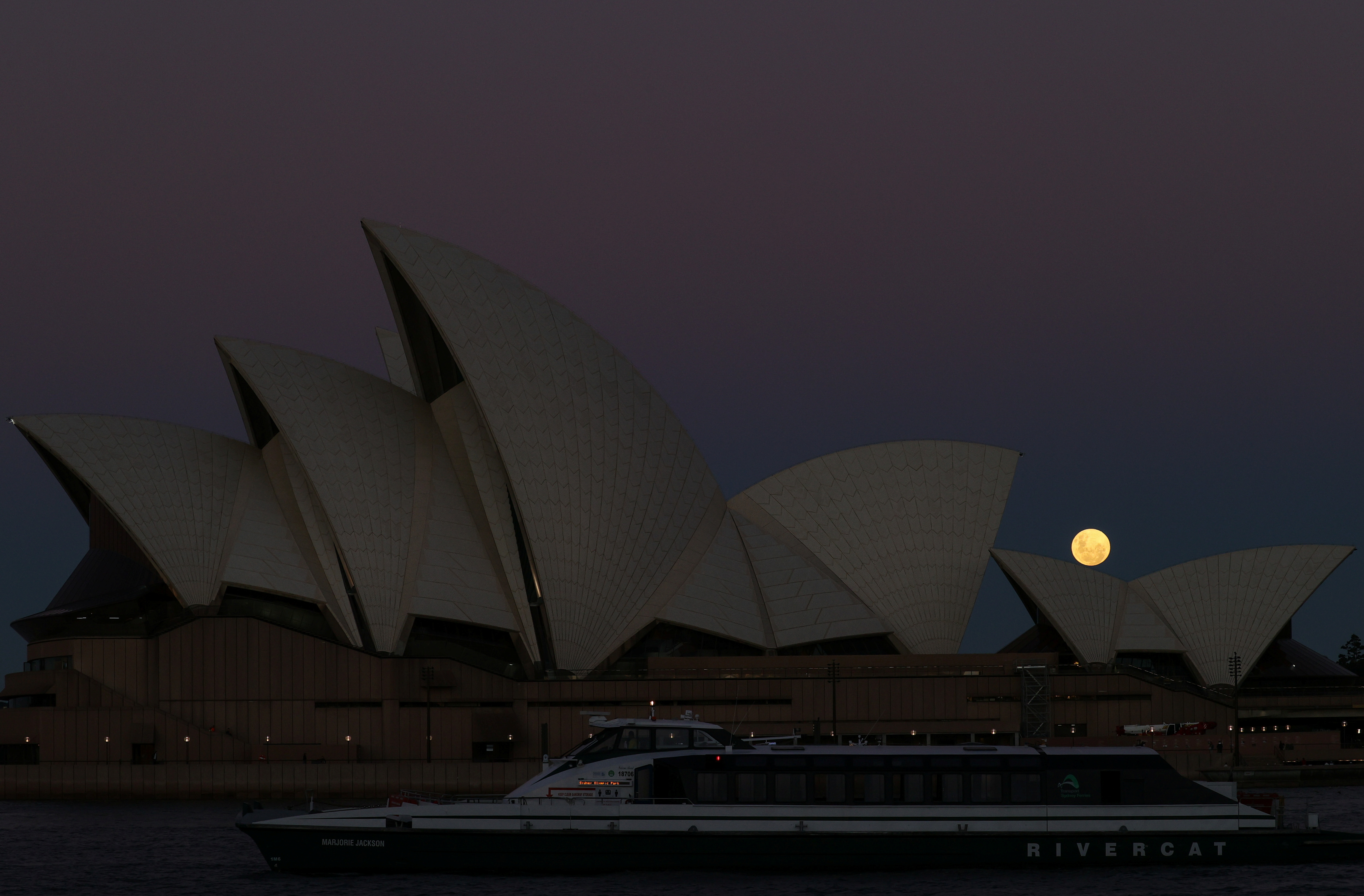 A Super Flower Moon rises behind the Sydney Opera House on the night of a lunar eclipse, in Sydney, Australia, May 26, 2021.  REUTERS/Loren Elliott