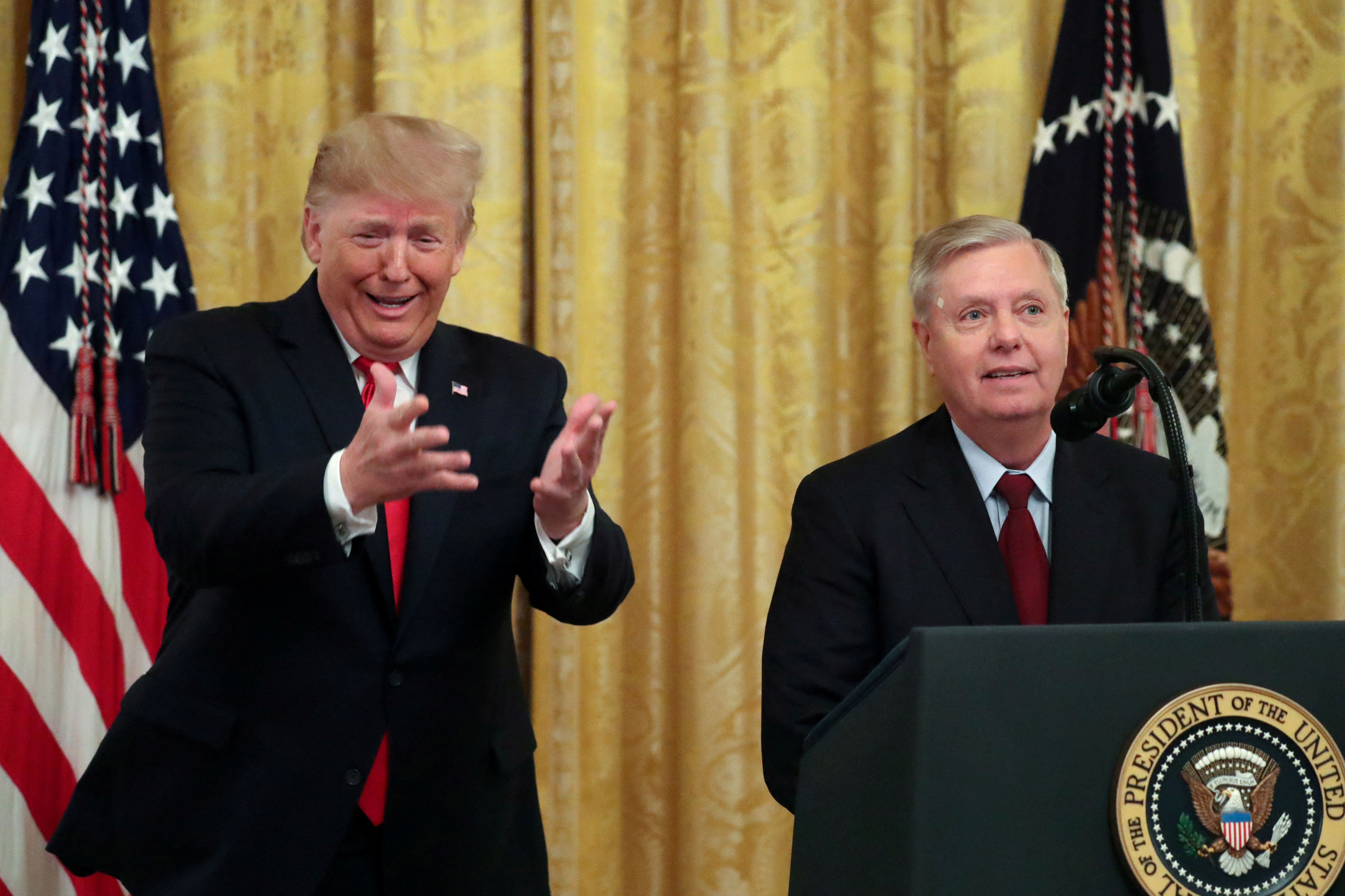 U.S. President Trump jokingly urges Graham and his fellow senators to return to the Capitol to vote for more judge nominees during an event to celebrate federal judicial confirmations in the East Room of the White House in Washington
