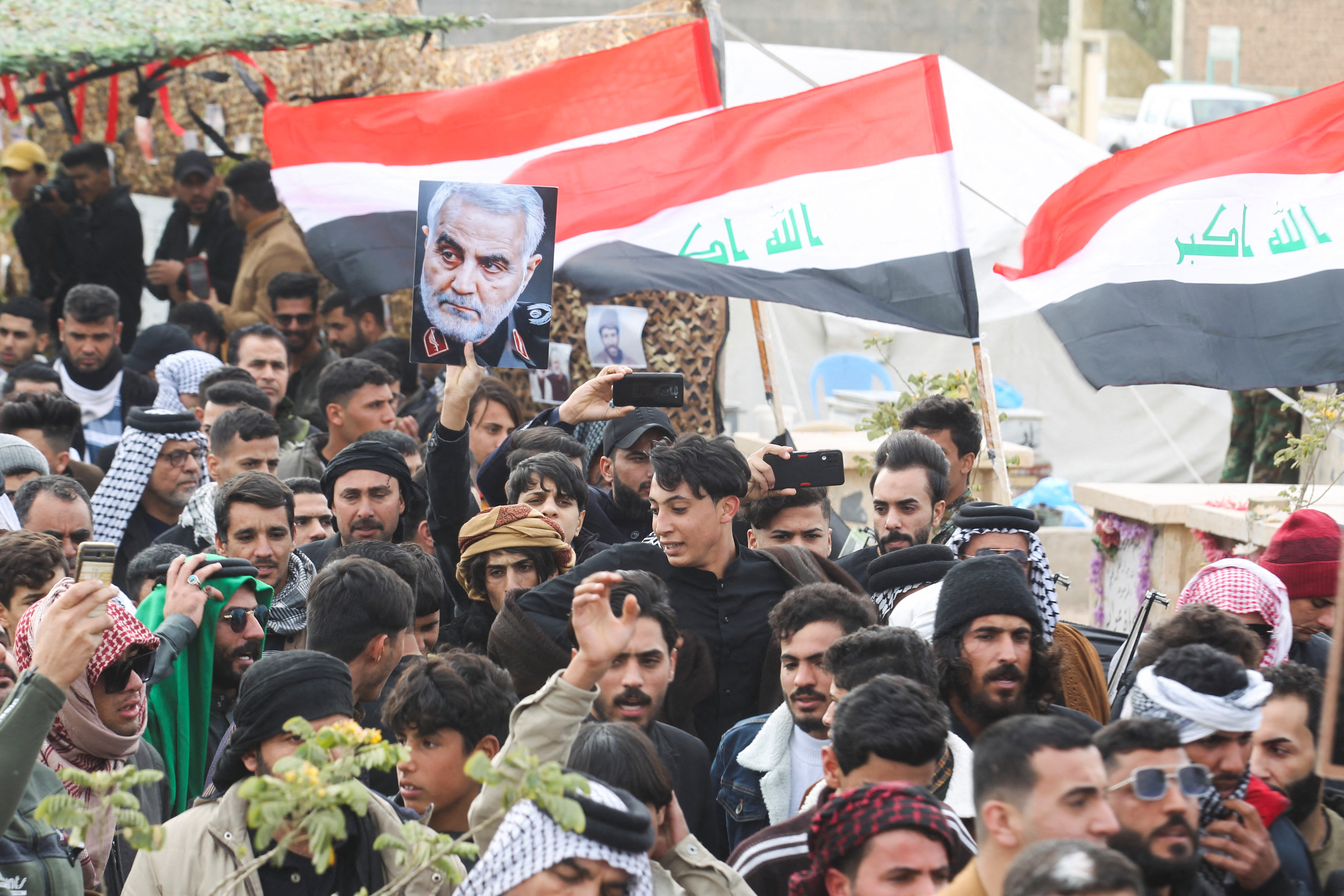 Iraqis, and supporters of Hashid Shaabi, gather as they visit the grave of Iraqi militia commander Abu Mahdi al-Muhandis