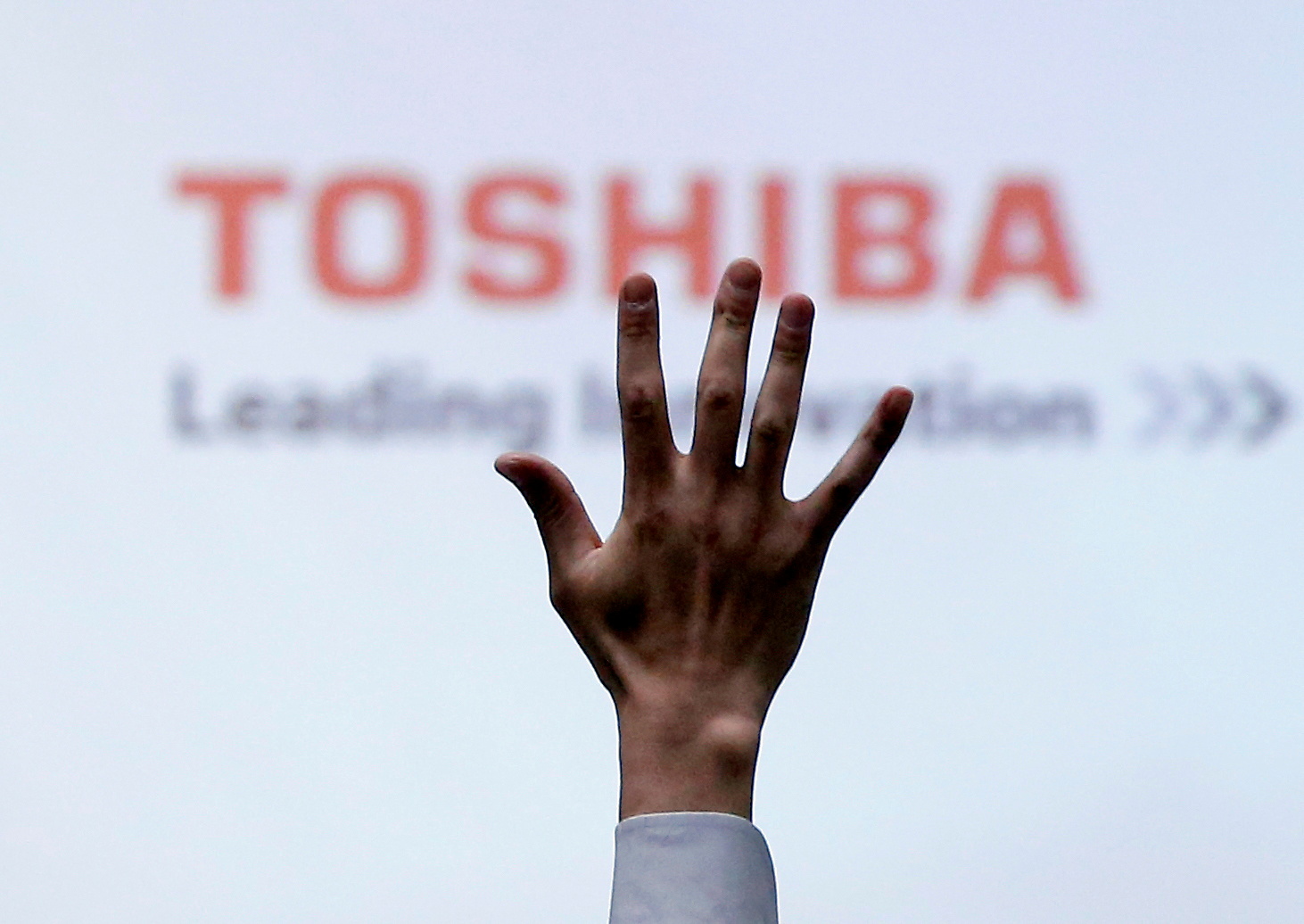 A reporter raises his hand for a question during a news conference by Toshiba Corp CEO Satoshi Tsunakawa at the company headquarters in Tokyo