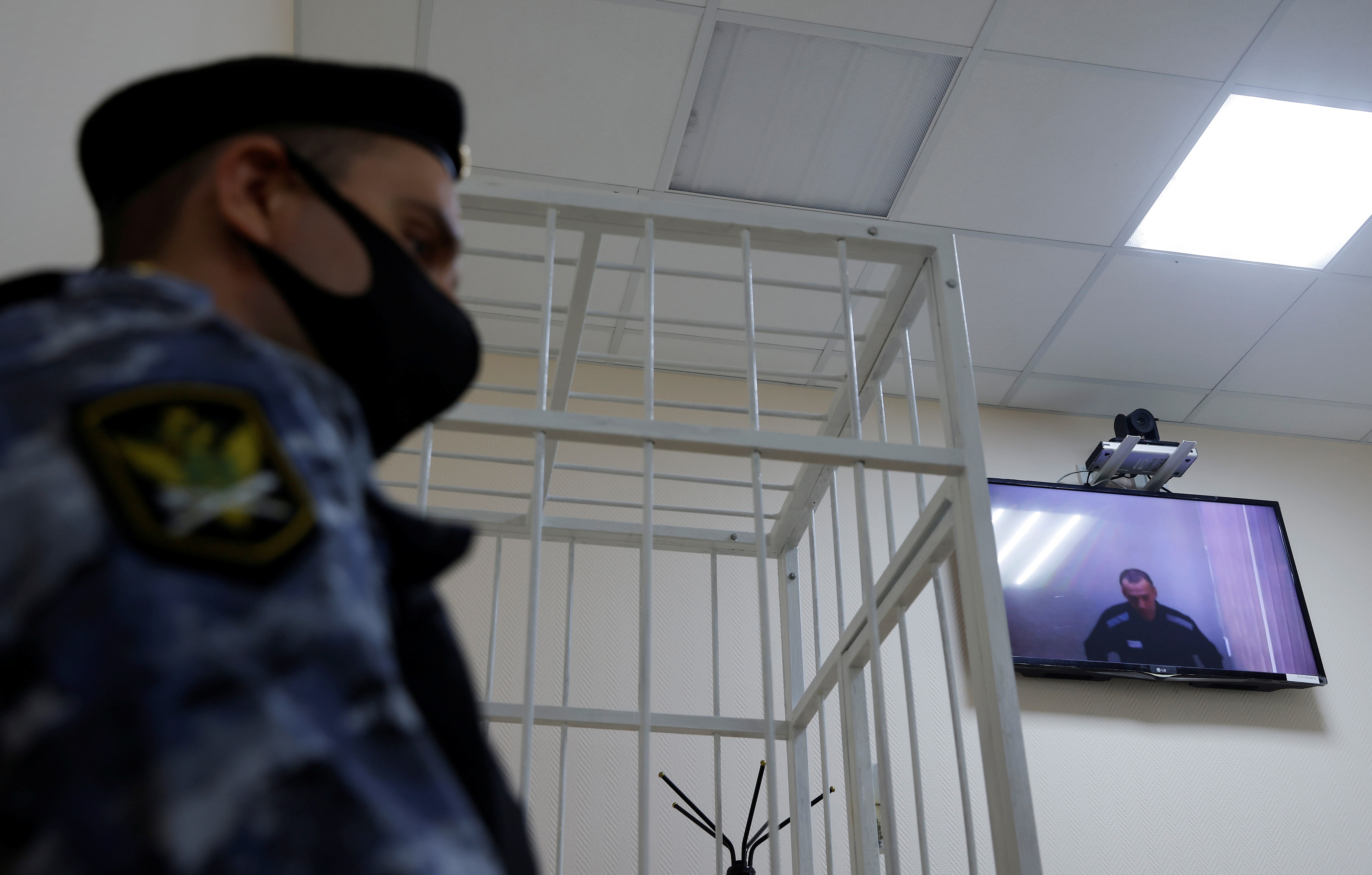 Russian opposition leader Alexei Navalny is seen on a screen via a video link during a hearing in Petushki