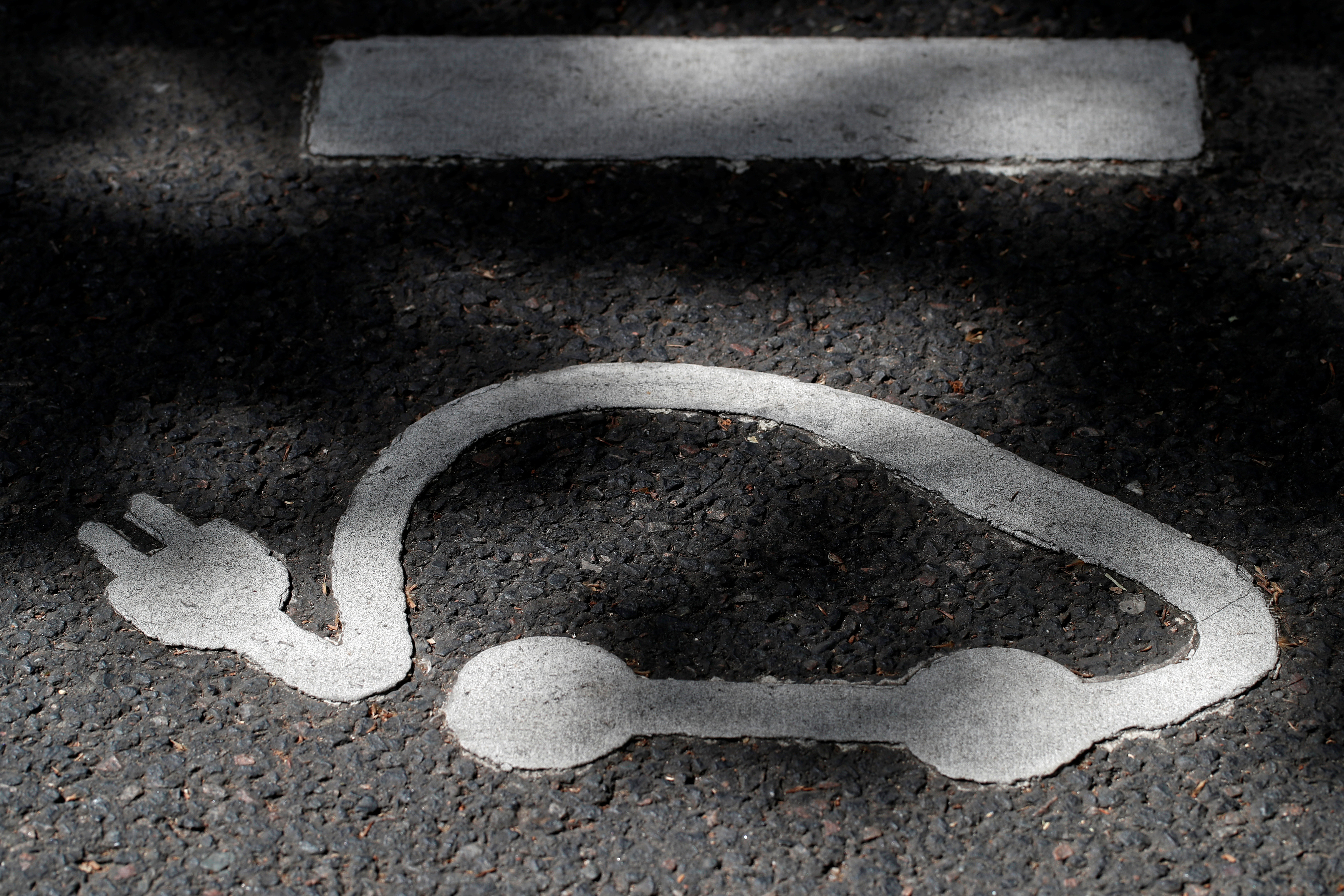 An Autolib' electric car-sharing logo is painted on the road at an Autolib' charging station in Paris