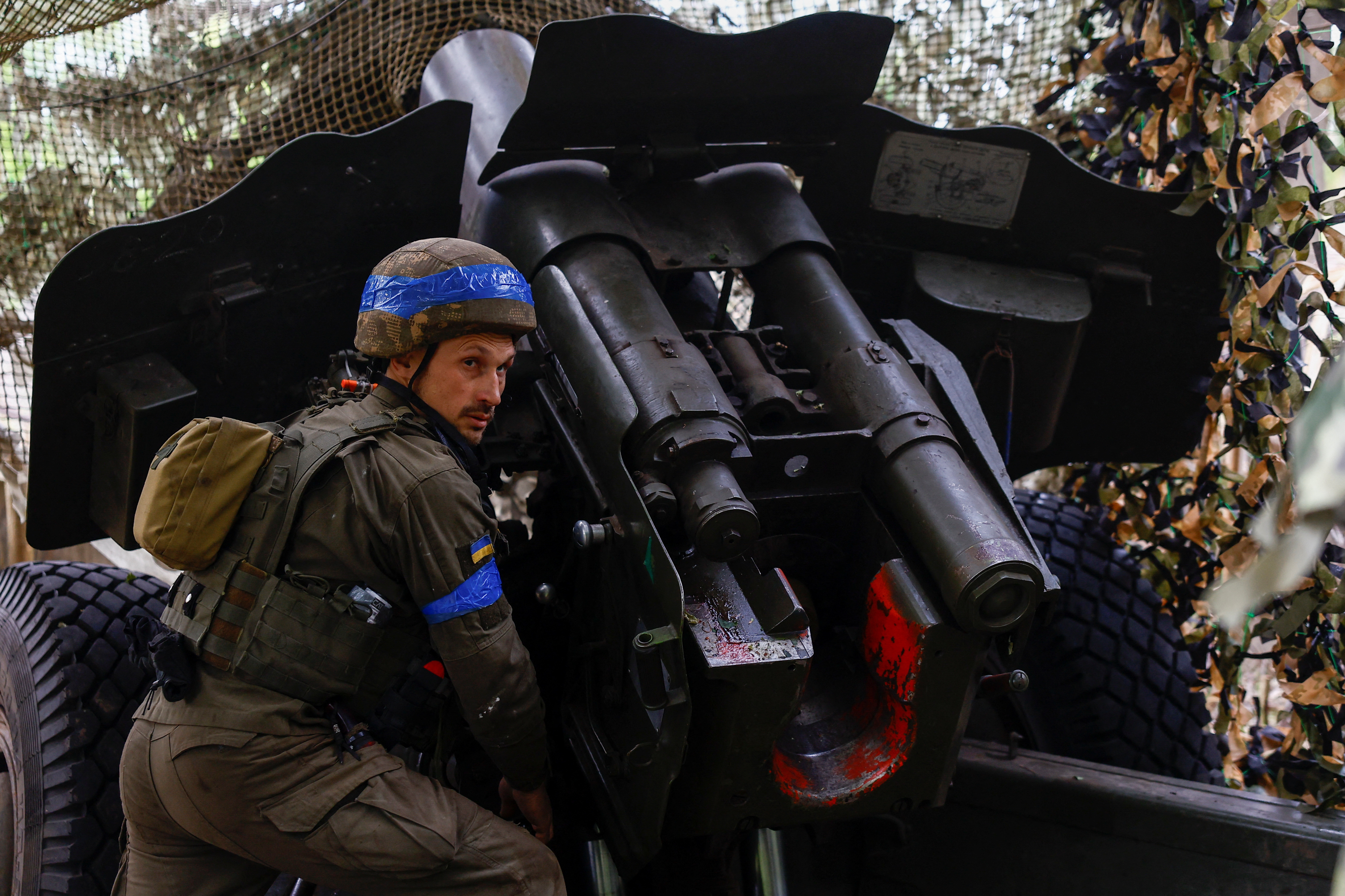 Ukrainian National Guard 'Khartiia' brigade service member and a D-20 howitzer crew commander Ivan Liashko prepares to fire towards Russian troops in a front line in Kharkiv region