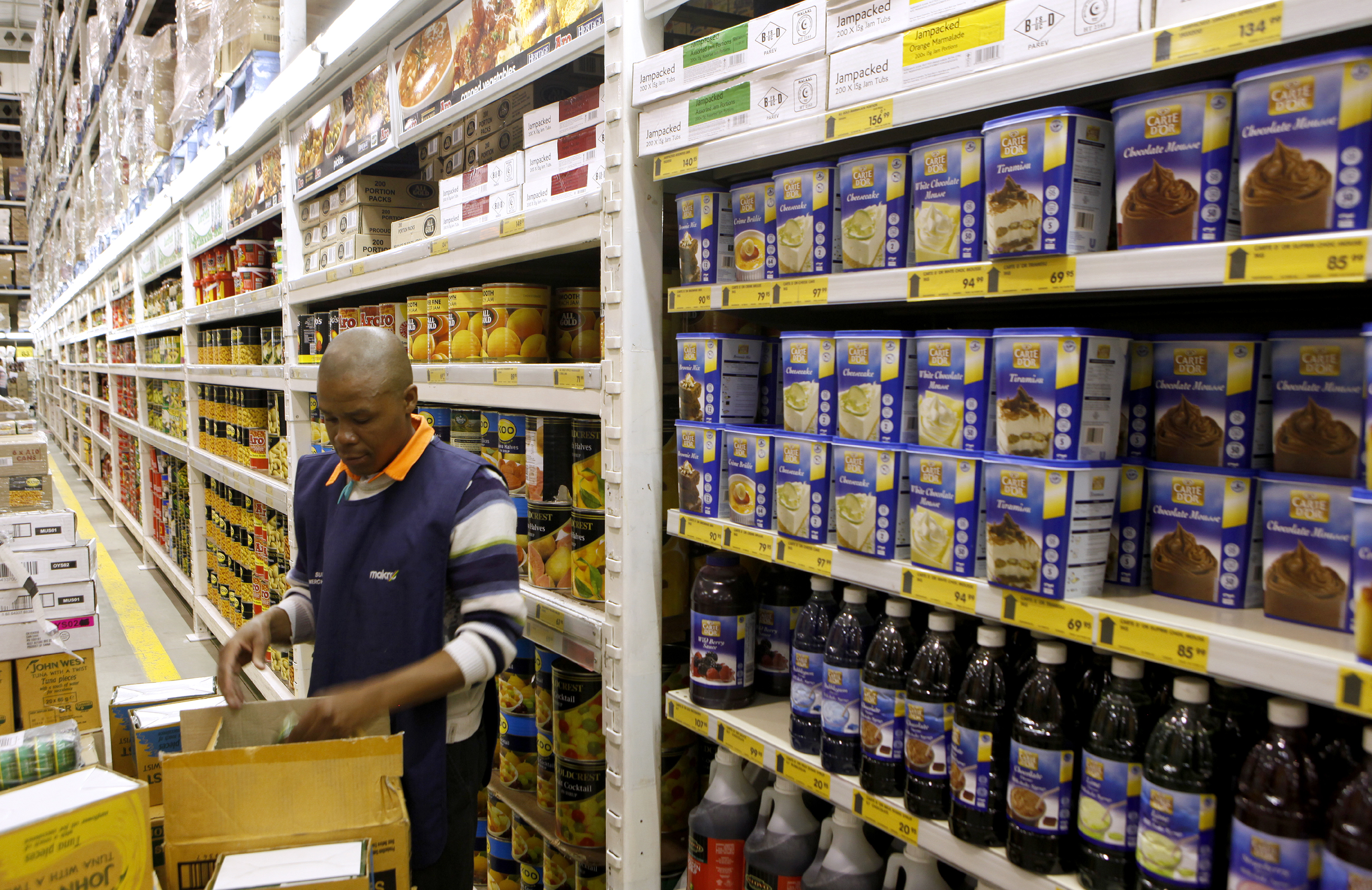 A worker arranges goods at a Makro branch of South African retailer Massmart in Johannesburg