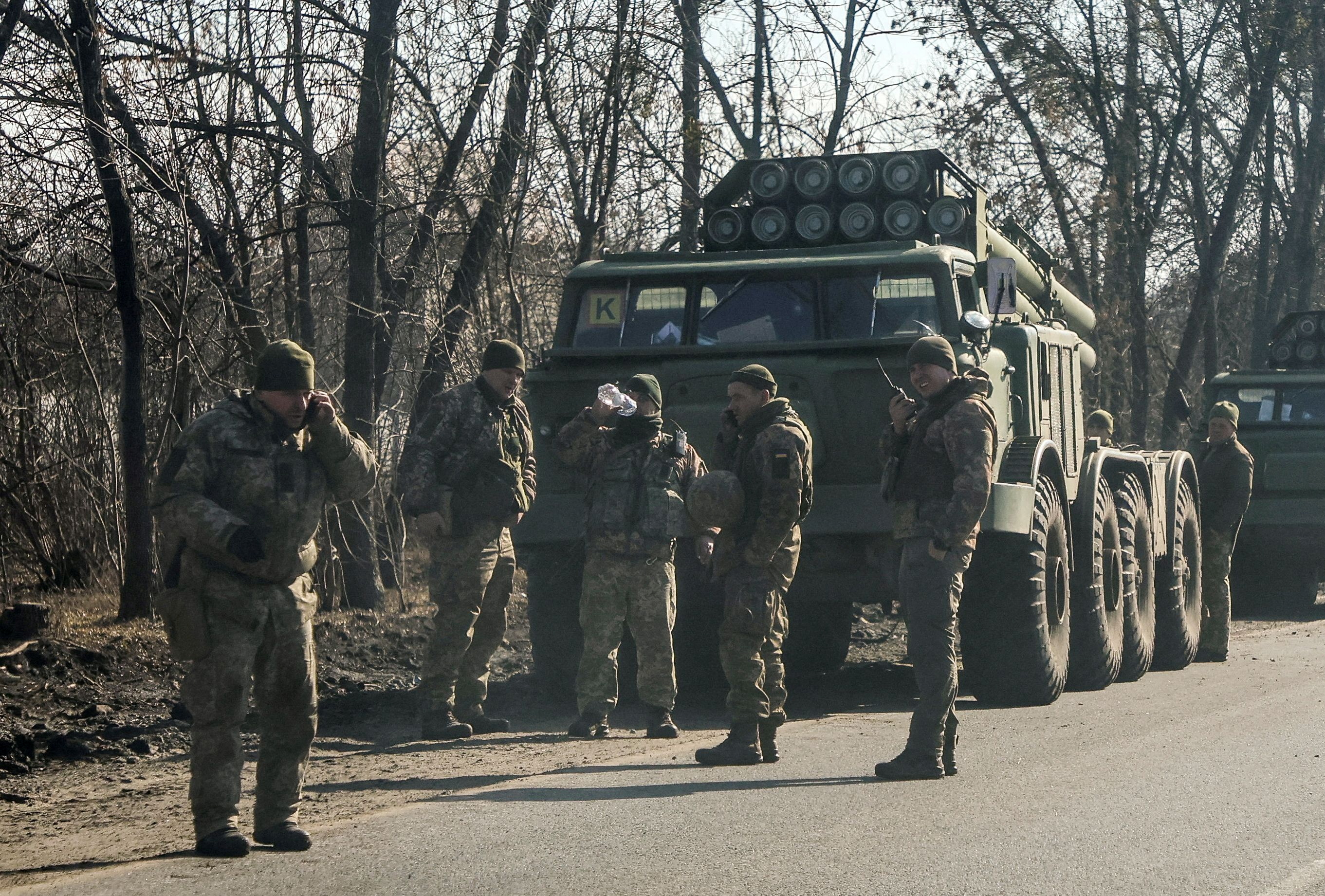 Ukrainian army soldiers stand next to multiple launch missile systems in Kharkiv region