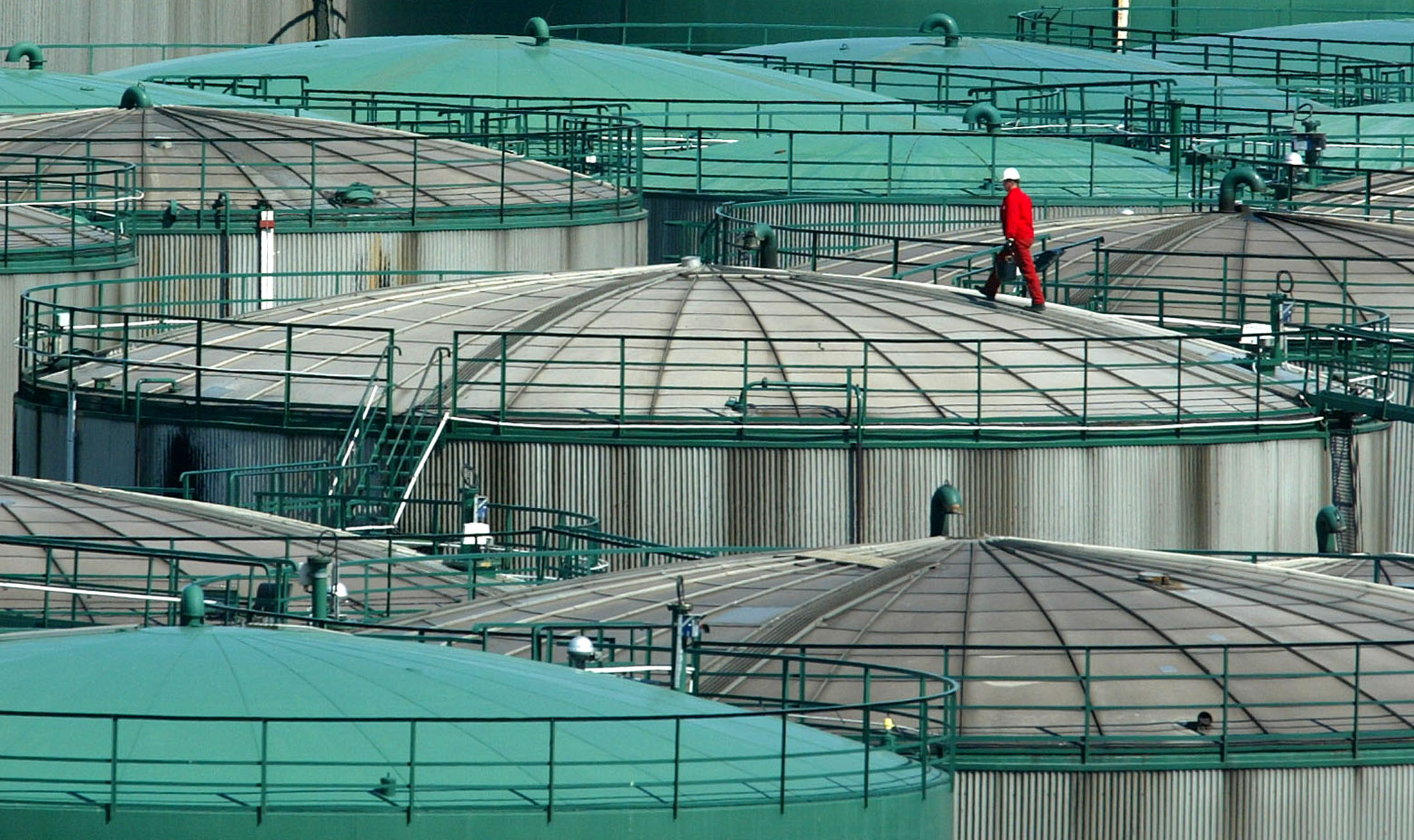 WORKER TAKES SAMPLE FROM AN OIL STORAGE TANK IN HAMBURG.