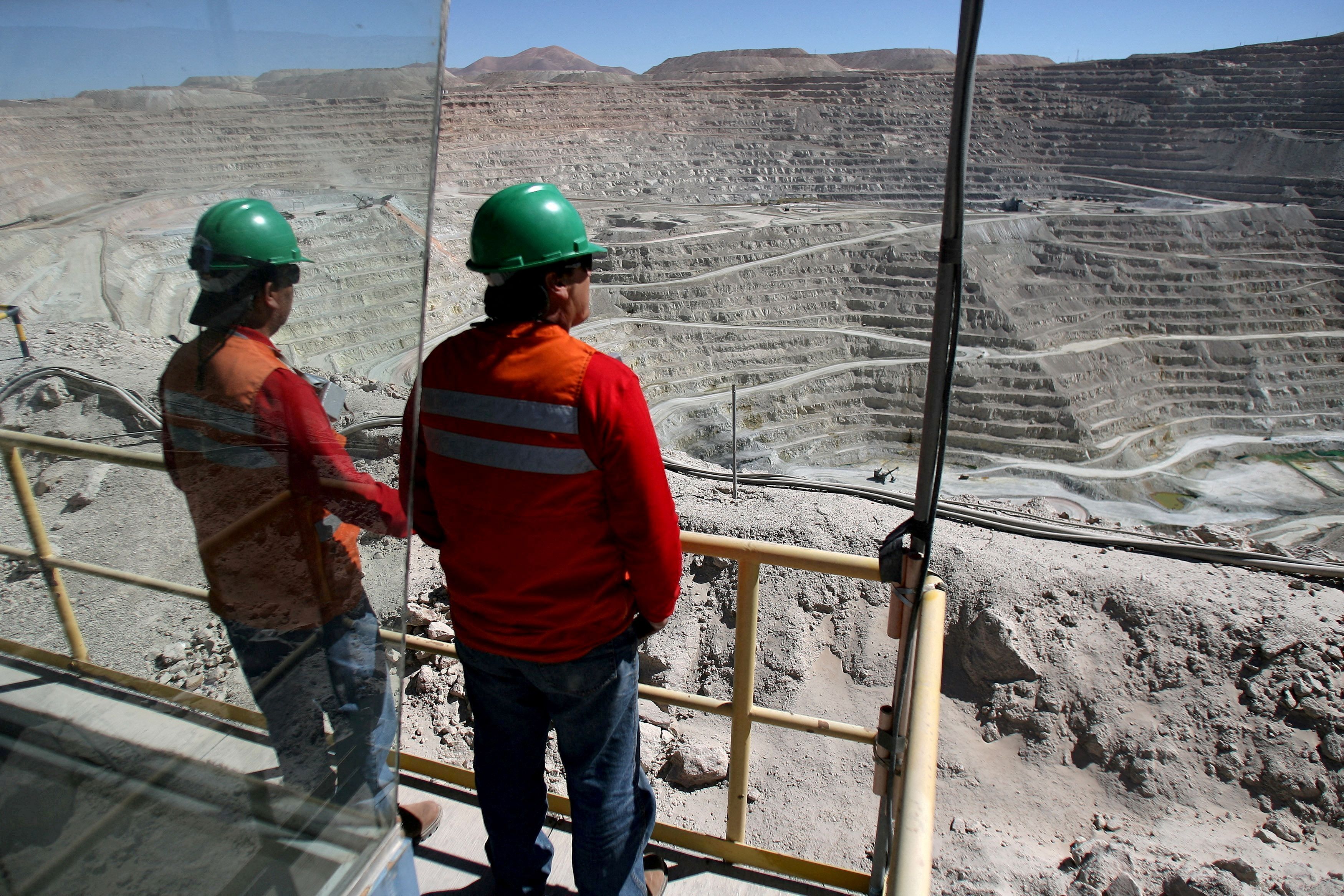 Workers at BHP Billiton's Escondida, the world's biggest copper mine, are seen in front of the open pit in Antofagasta